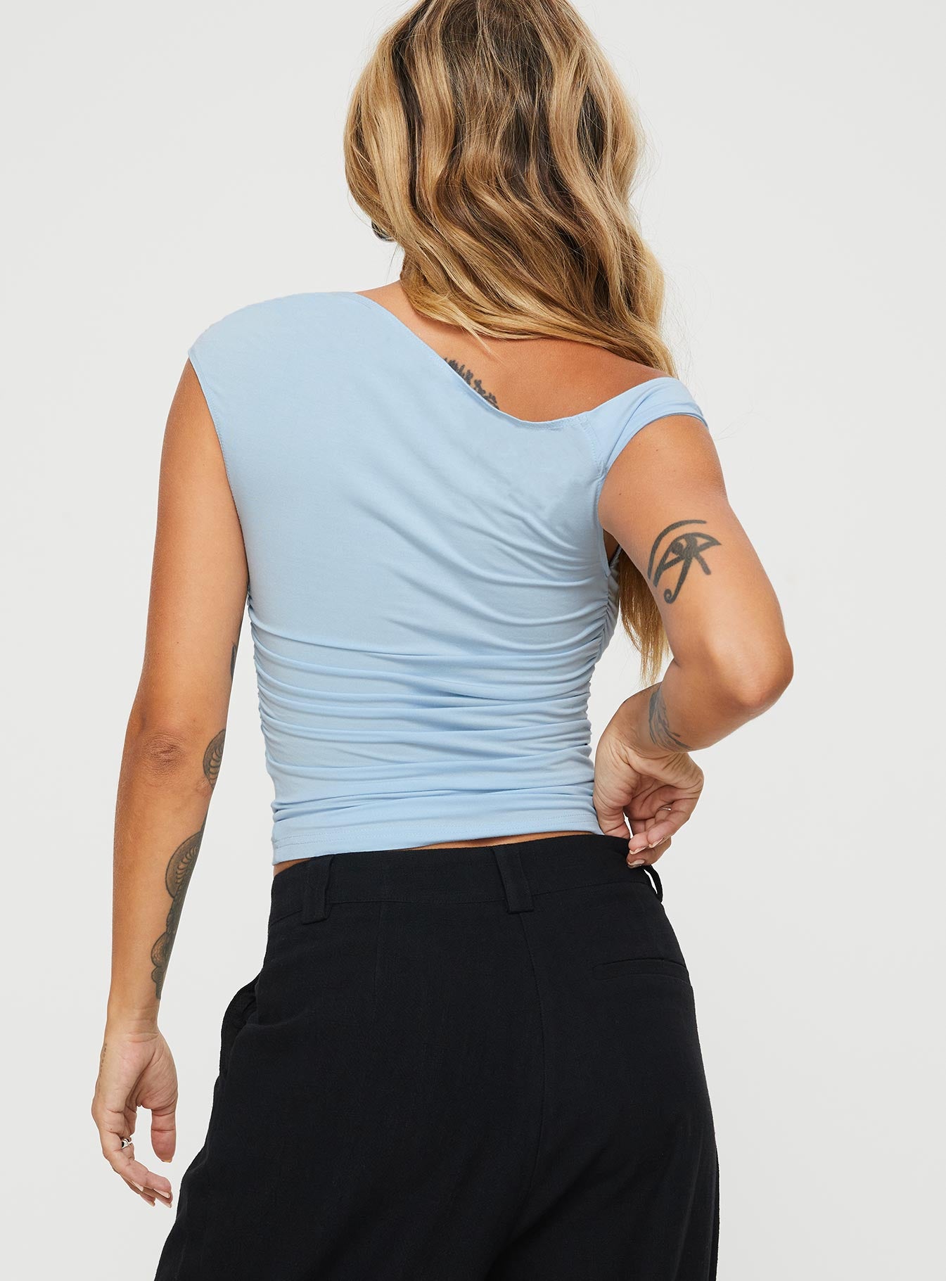 back view of model wearing Princess Polly Beller Top Blue Sleeveless Asymmetric Neckline 