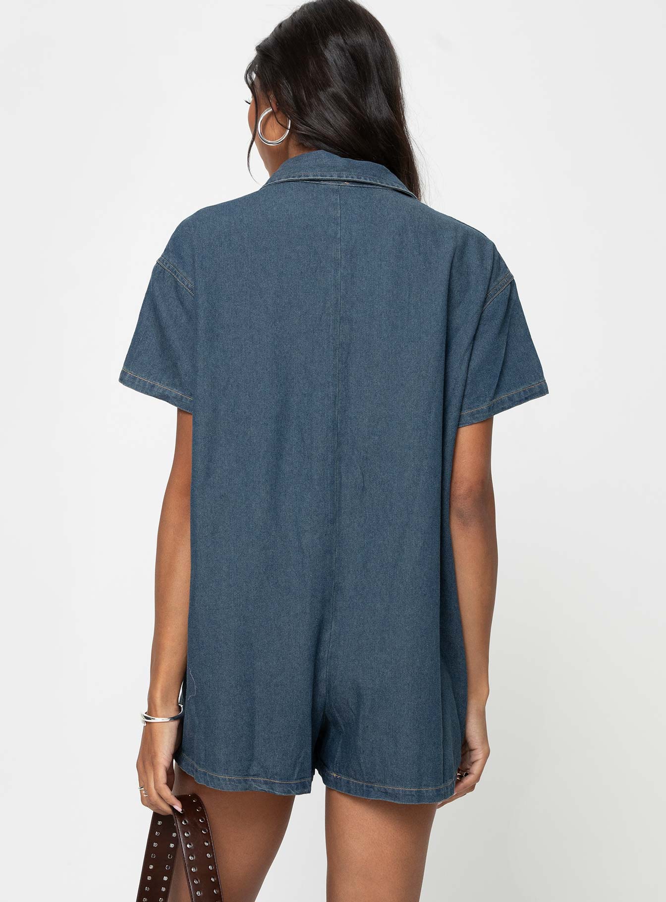 Dark wash denim romper Classic collar, button fastening down front, chest pocket, drop shoulder Non-stretch material, unlined 