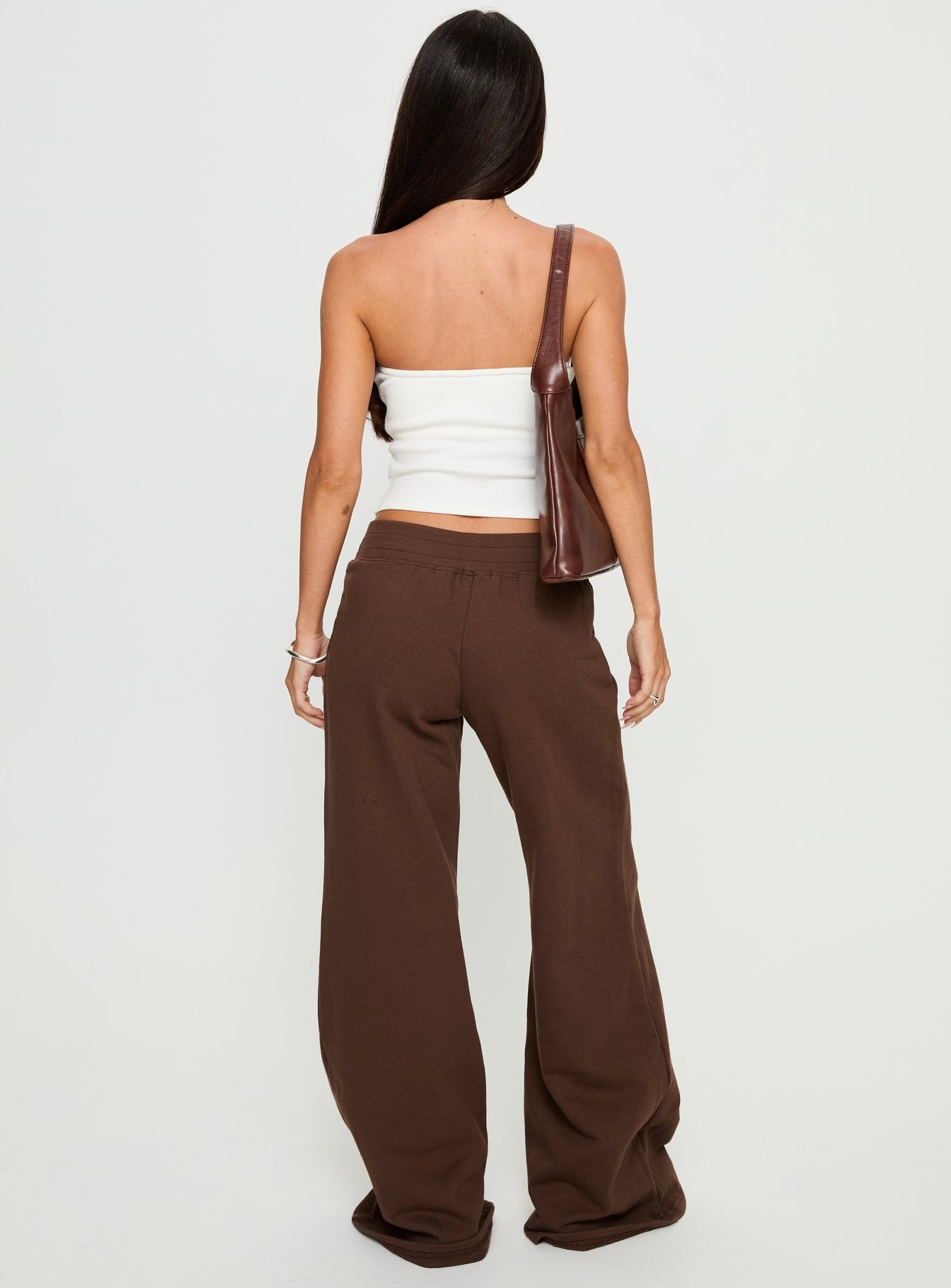 back view of model wearing Princess Polly Summits Flared Track Pants Chocolate High Rise Pants 