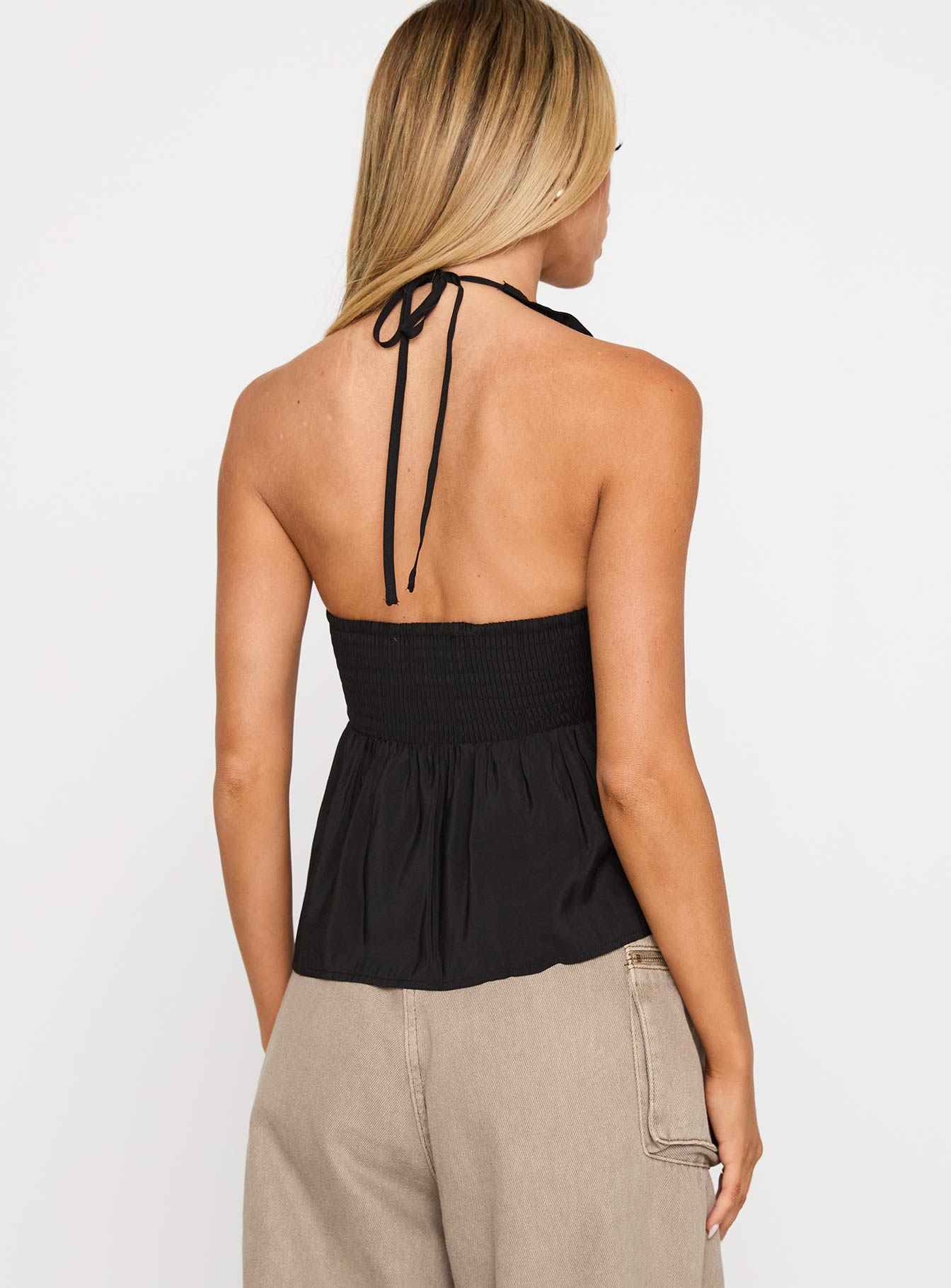 back view of model wearing Princess Polly Gadot Halter Top Black Sleeveless Plunger 