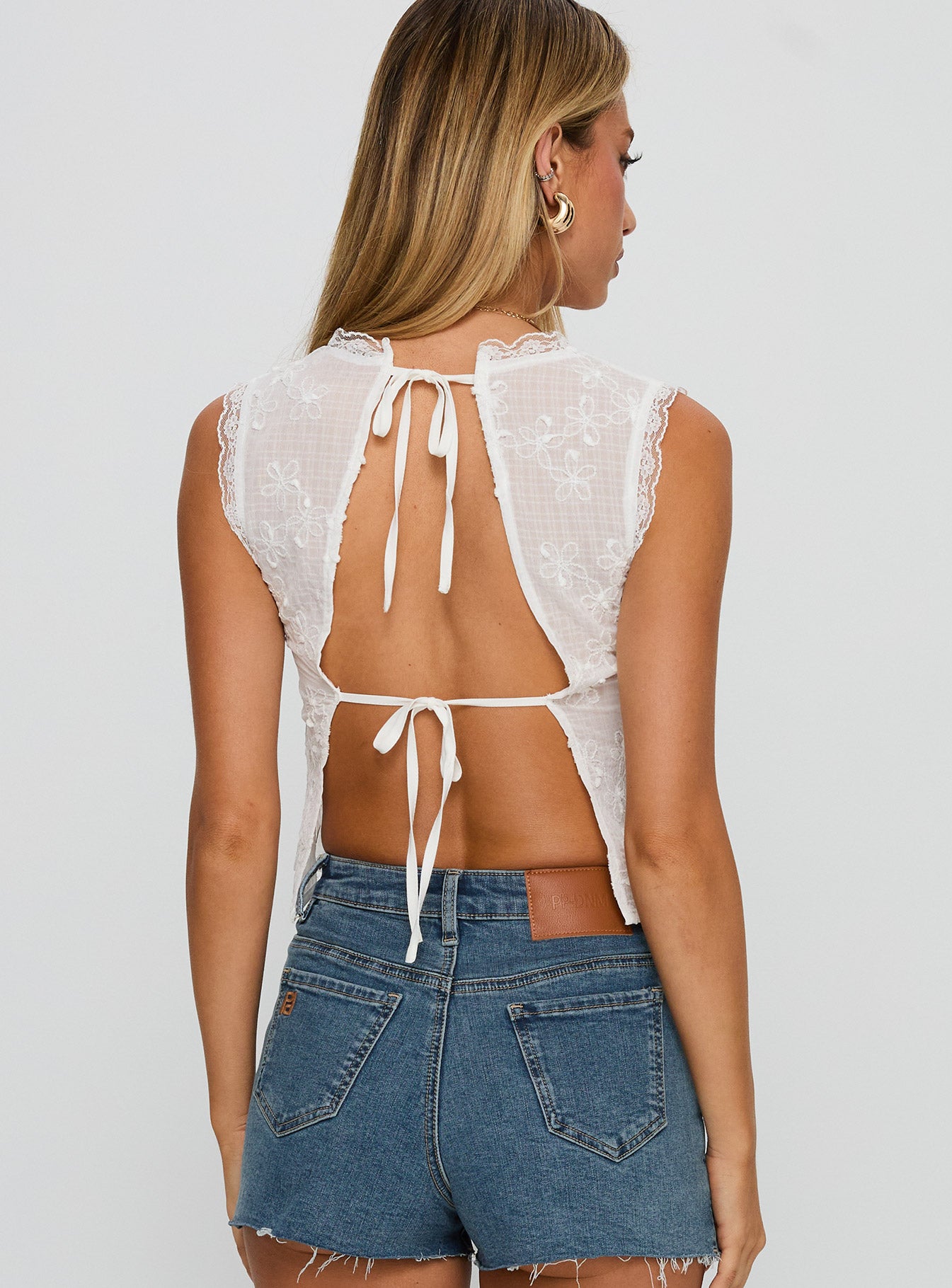 back view of model wearing Princess Polly Hagea Top White Sleeveless Plunger 