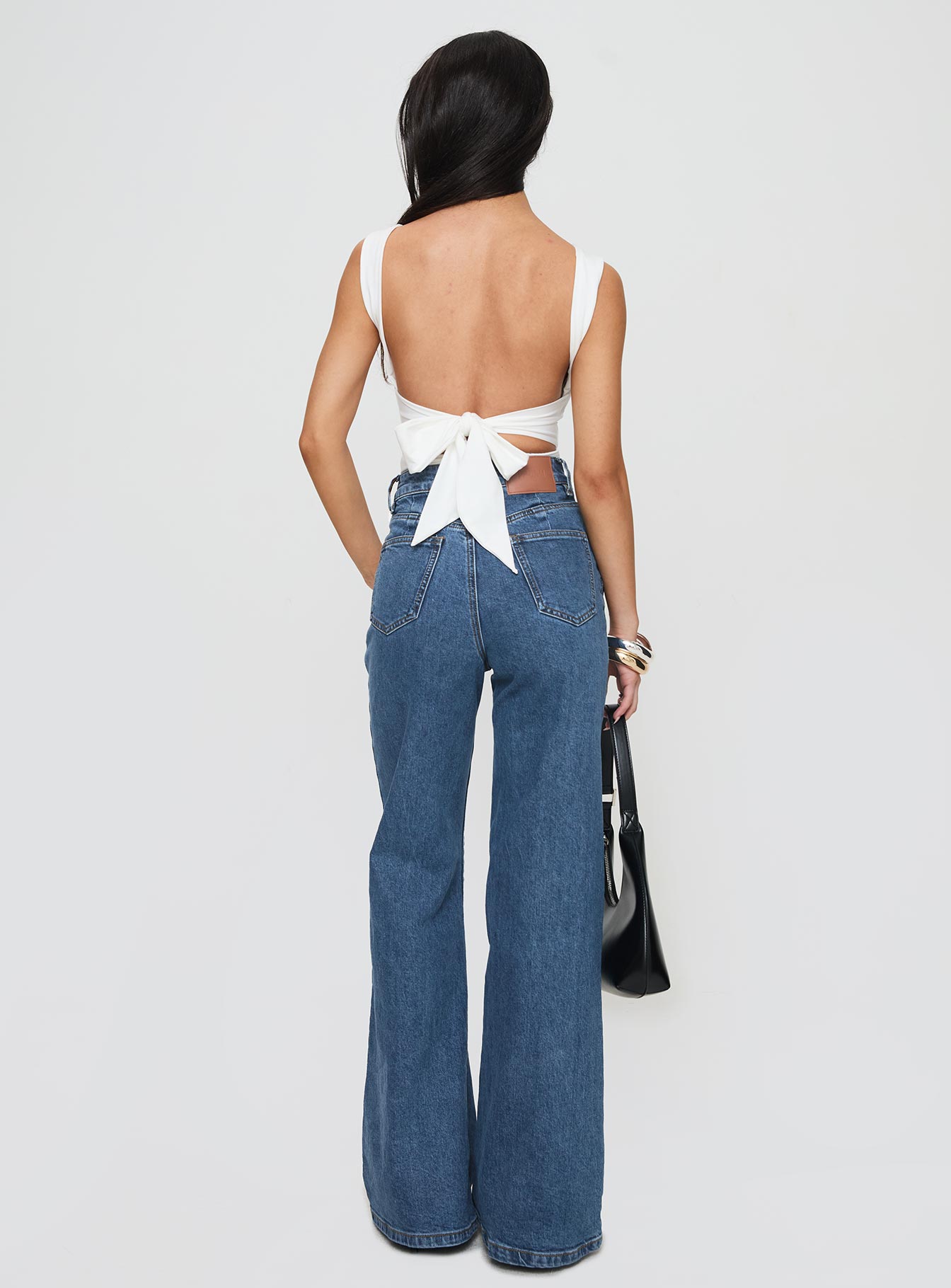 back view of model wearing Princess Polly Lucille High Rise Flare Leg Jeans Mid Wash High Waisted 
