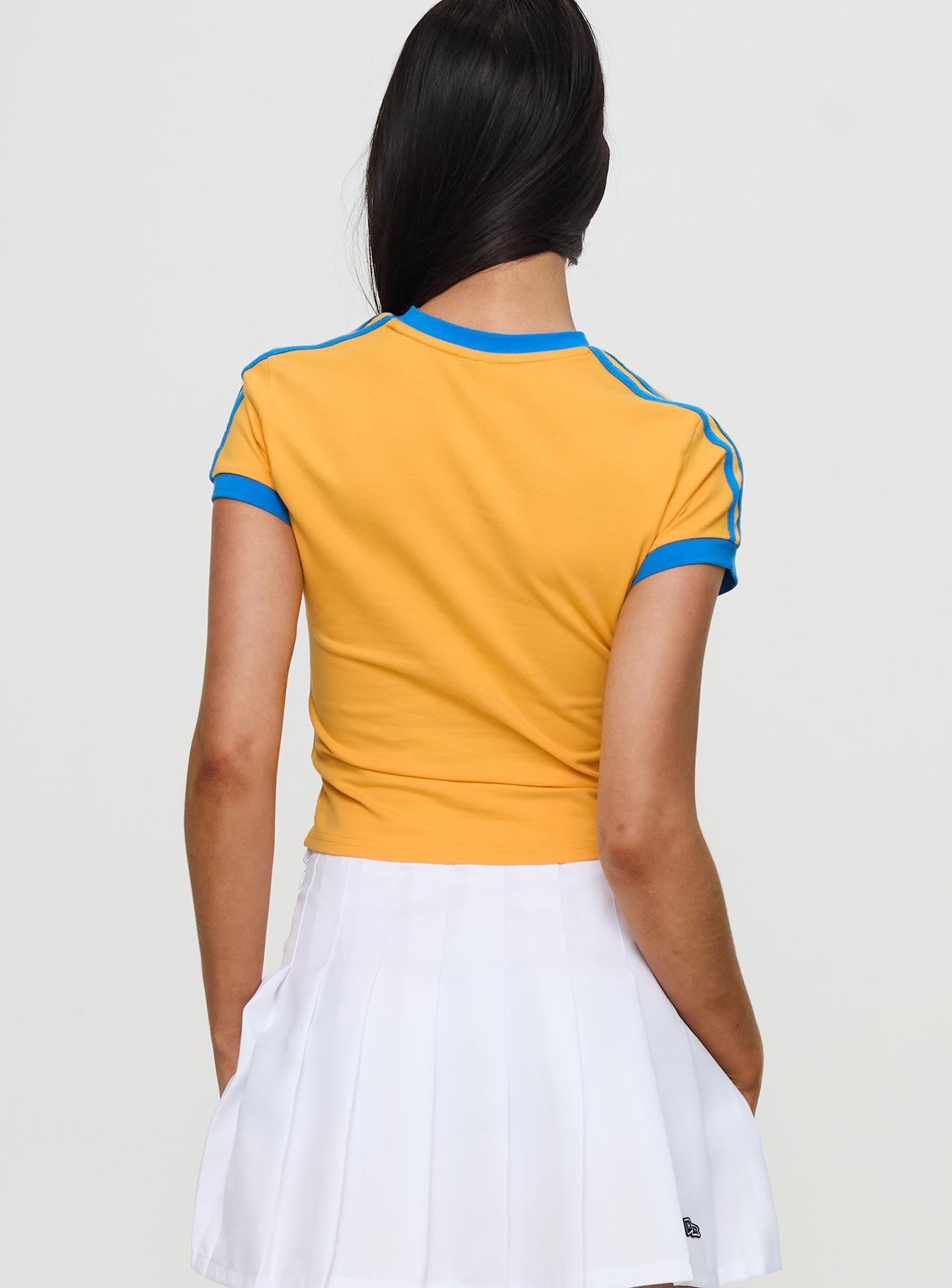 back view of model wearing Princess Polly UCLA Goalie Baby Tee Yellow Short Sleeves Crew Neck 