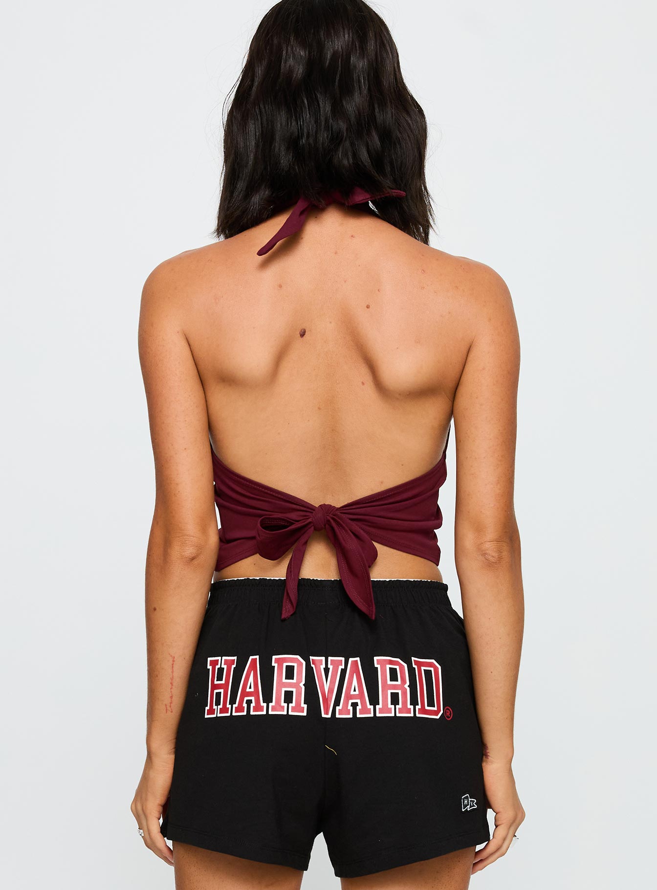 back view of model wearing Princess Polly Harvard Tailgate Halter Top Red Sleeveless Scoop Neck 