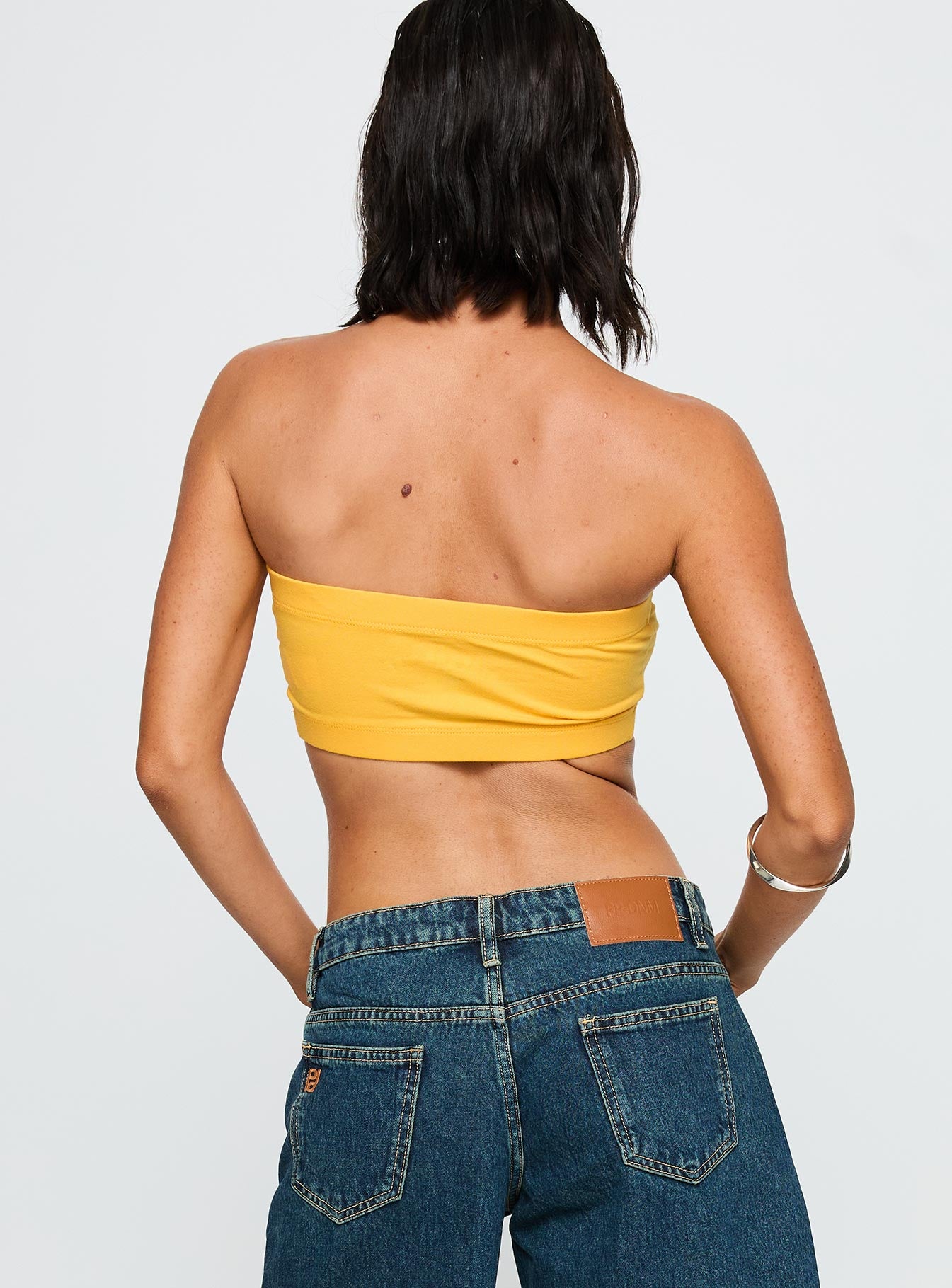 back view of model wearing Princess Polly UC Irvine Bandeau Top Gold Sleeveless straight 