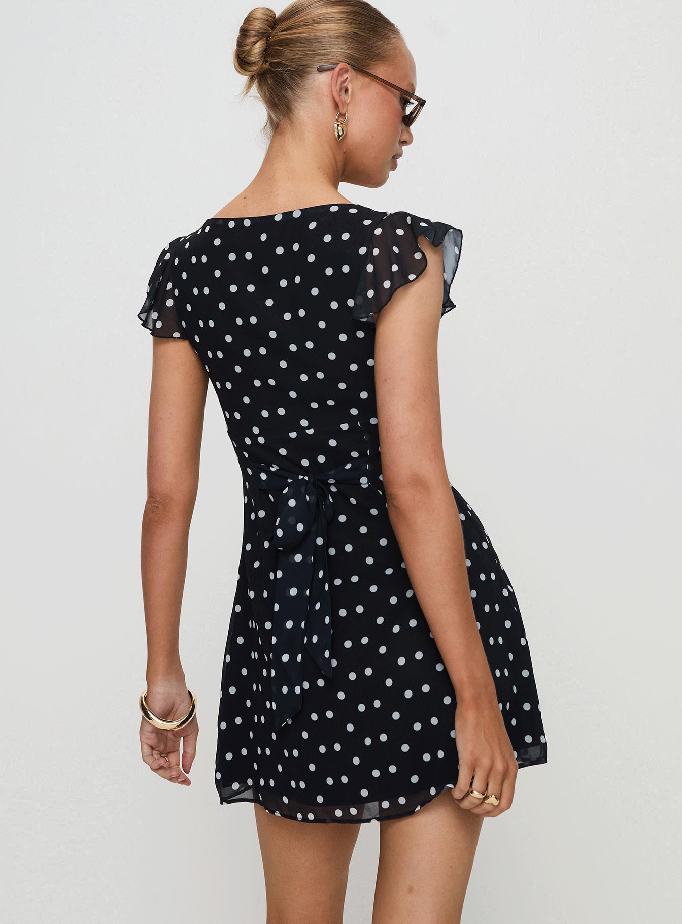 back view of model wearing Princess Polly I Guess So Mini Dress Black Polka Dot Petite V-Neck 