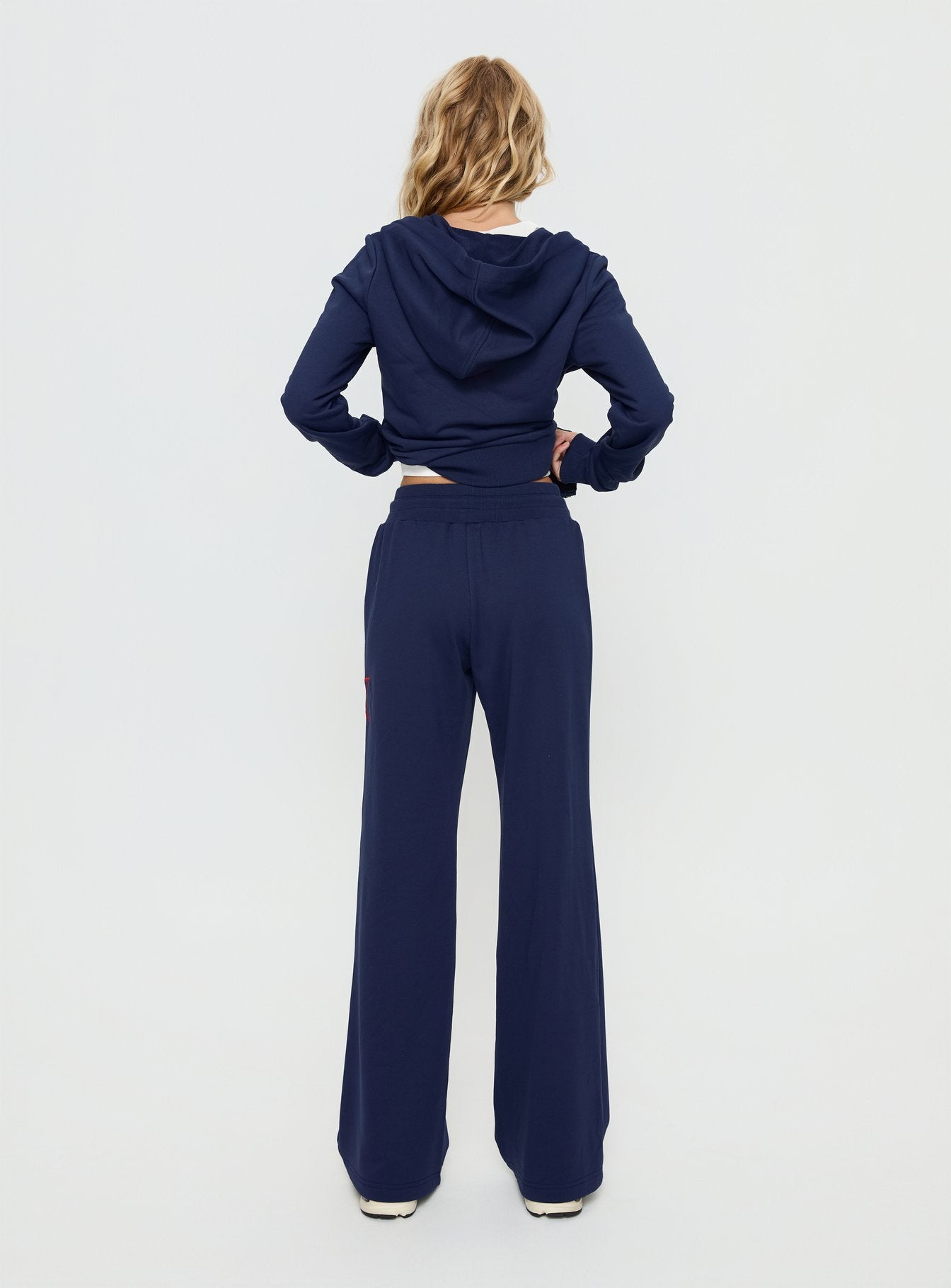 back view of model wearing Princess Polly Kari Distressed Patch Track Pant Navy Multi High Rise Pants 