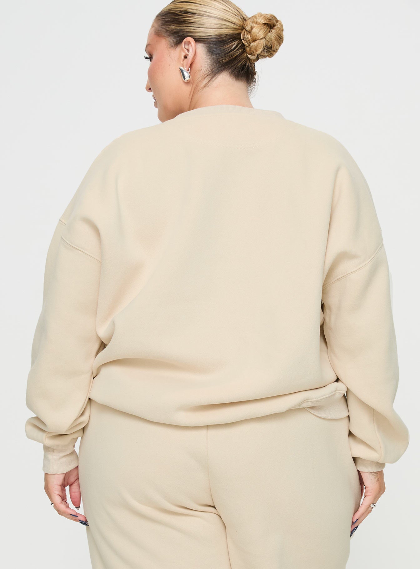 back view of model wearing Princess Polly Princess Polly Crew Neck Sweatshirt Block / Cursive Text Stone Curve regular regular 