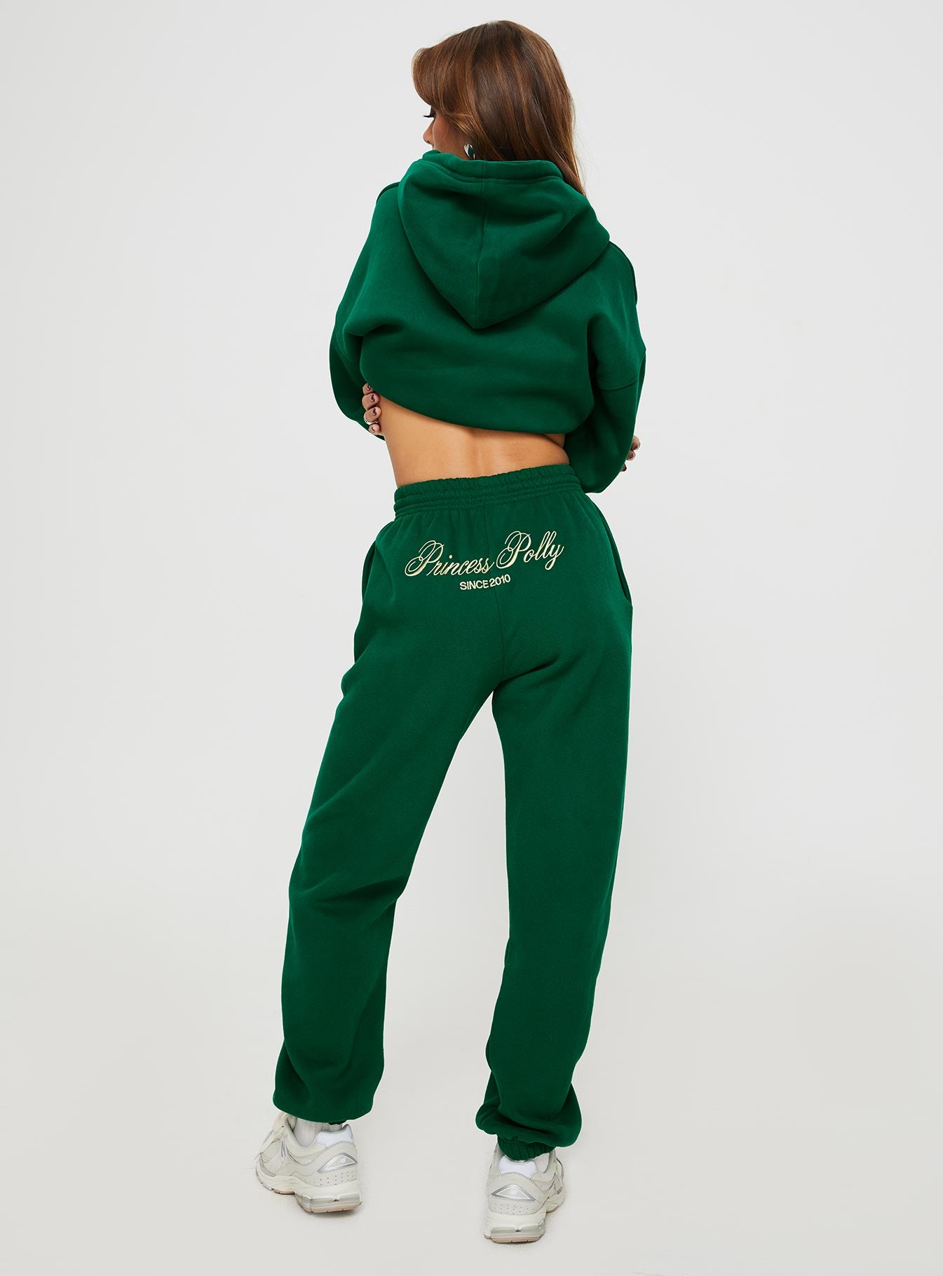back view of model wearing Princess Polly Princess Polly Track Pants Script Green / Ivory High Waisted Pants 