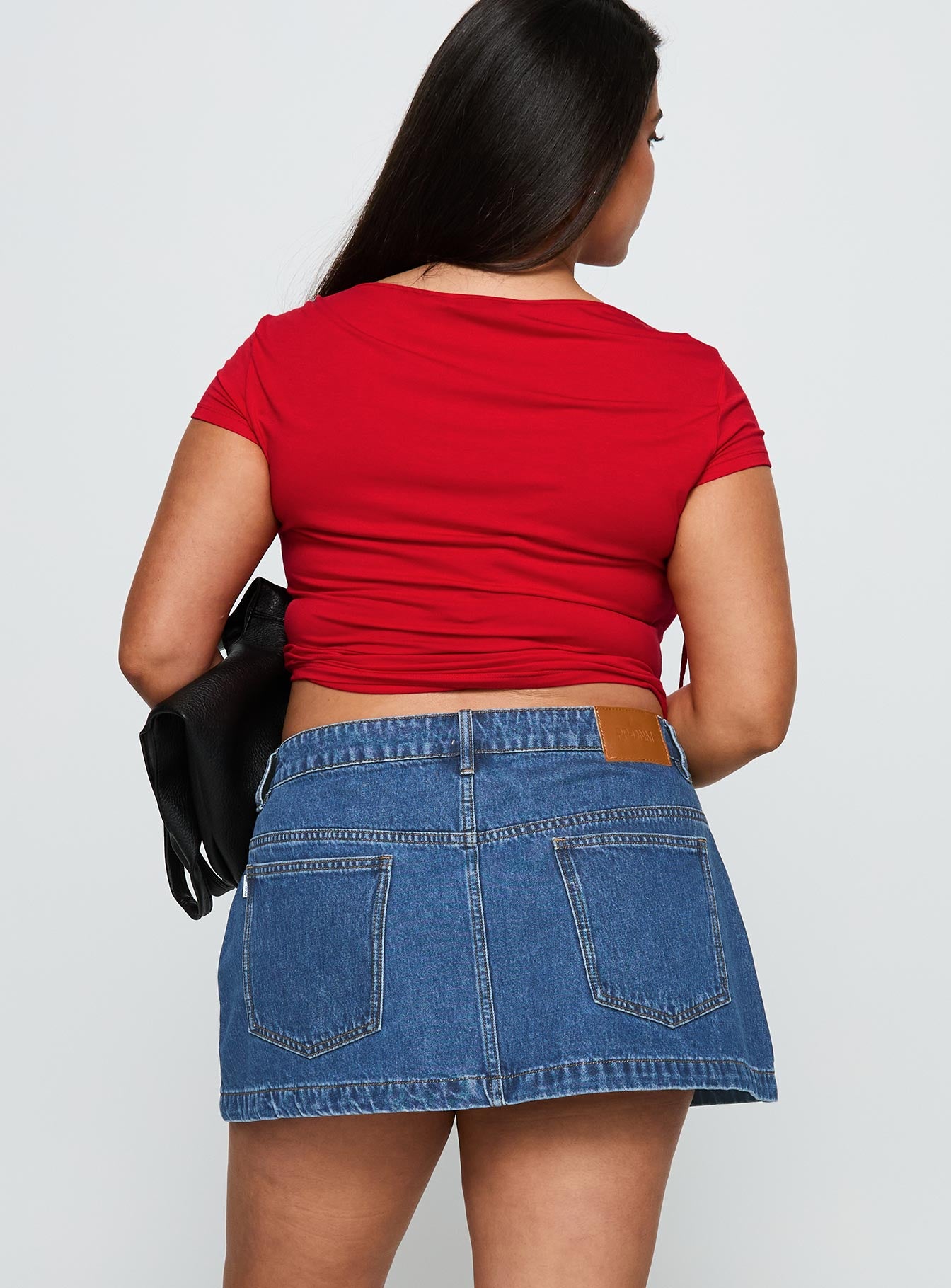 back view of model wearing Princess Polly Nicolina Low Rise Denim Mini Skirt Light Wash Curve Mini Skirts 