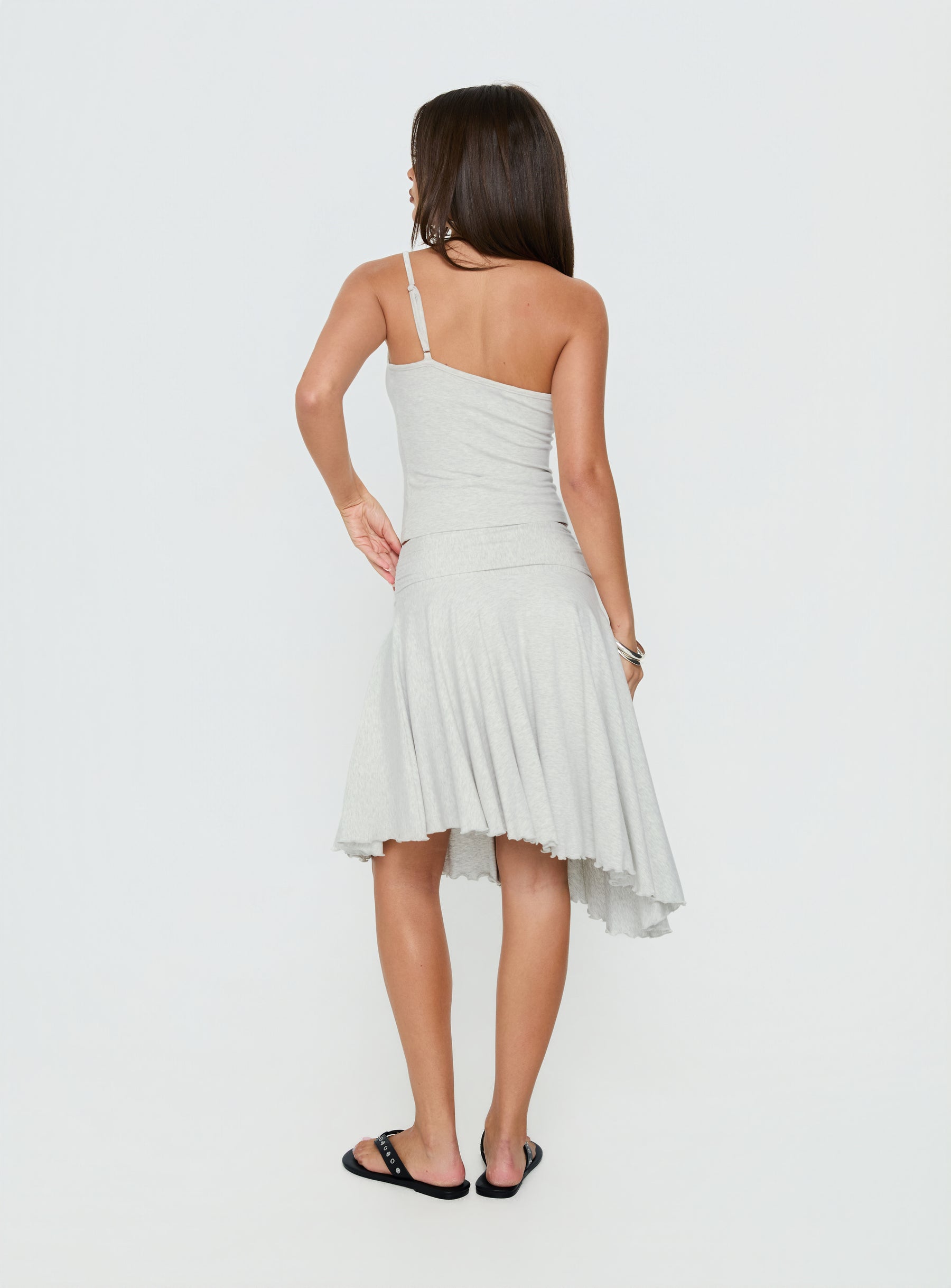 Styled in the Mimmi Asymmetrical Midi Skirt Grey womens-skirts featuring ruched fitted silhouette and frayed hem back view of model wearing Princess Polly