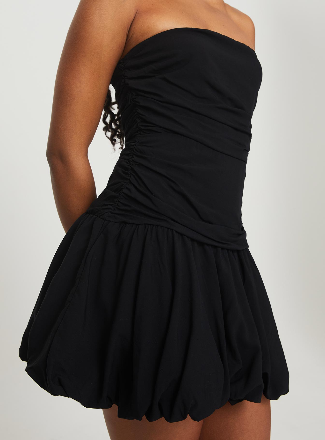 back view of model wearing Princess Polly Glamour Girl Strapless Bubble Hem Mini Dress Black Straight Neck 