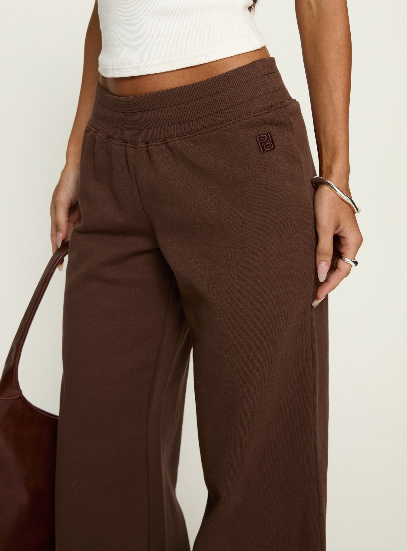 side view of model wearing Princess Polly Summits Flared Track Pants Chocolate High Rise Pants 