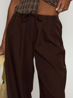 side view of model wearing Princess Polly Idolised Pleated Tie Waist Pant Chocolate Brown Mid Rise Pants 
