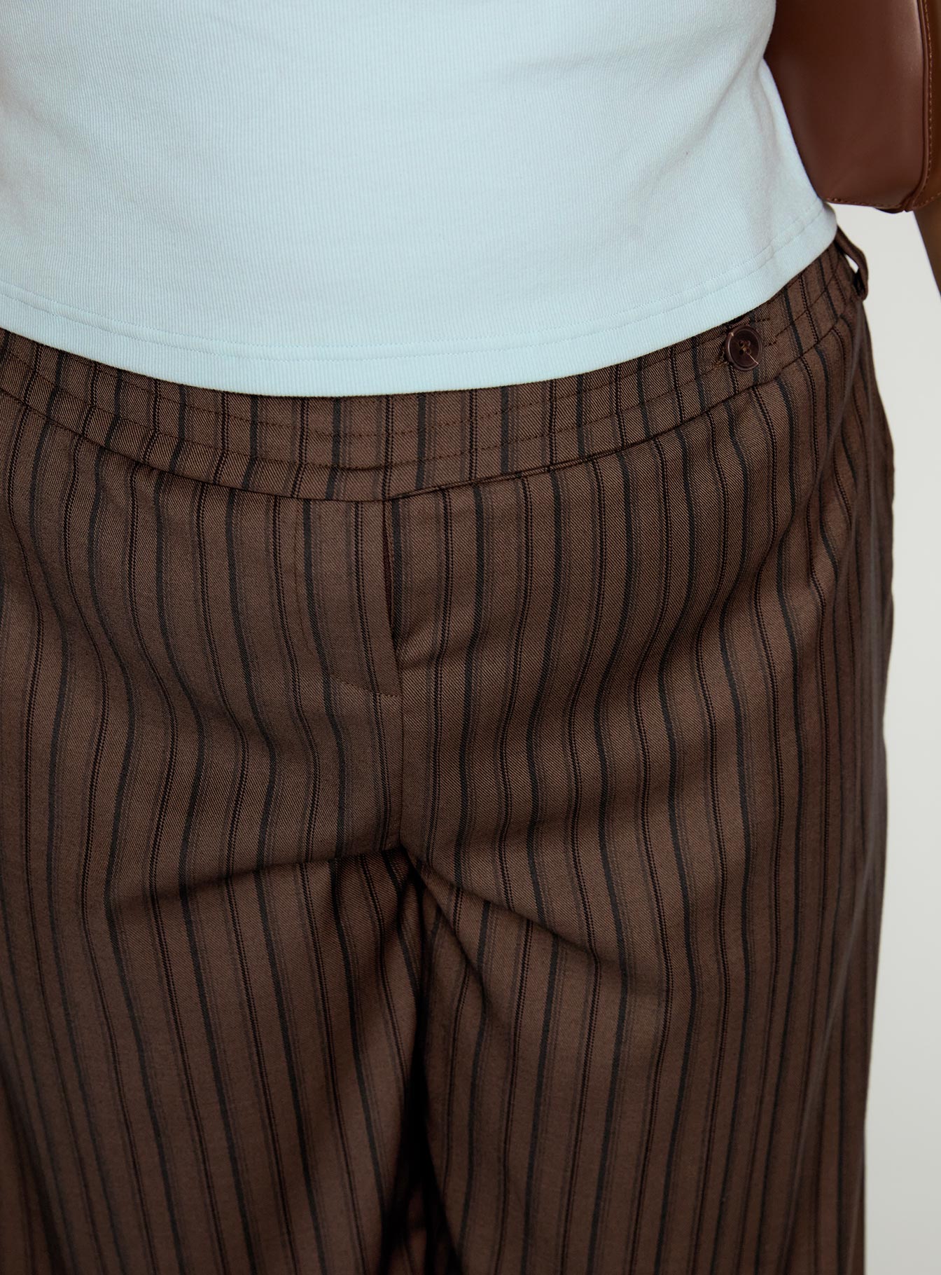 side view of model wearing Princess Polly Cedars Low Rise Pant Brown Stripe Curve Low Rise Pants 
