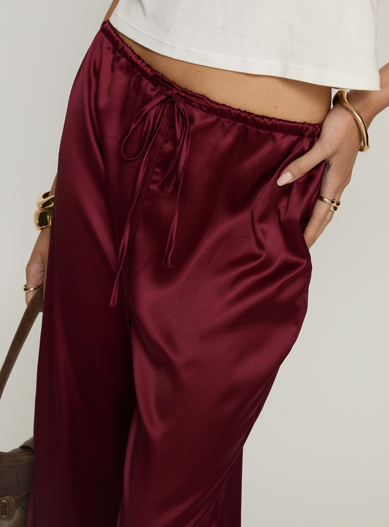 side view of model wearing Princess Polly Soulstar Satin Pants Wine Mid Rise Pants 