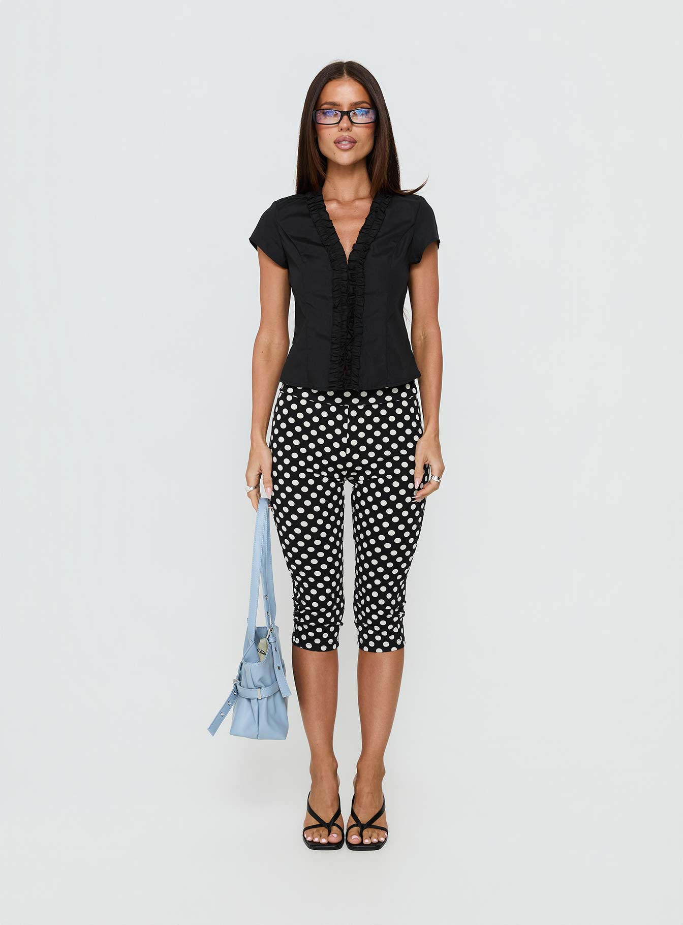 side view of model wearing Princess Polly Isadonna Capri Pants Black Polka Dot Mid Rise Pants 