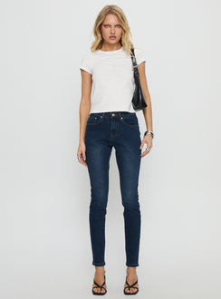 front view of model wearing Princess Polly Illyssa Mid Rise Skinny Jeans Mid Blue Wash Mid Rise Jeans 