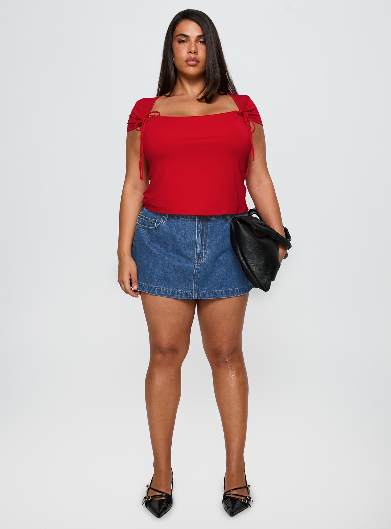   side view of model wearing Princess Polly Nicolina Low Rise Denim Mini Skirt Light Wash Curve Mini Skirts 