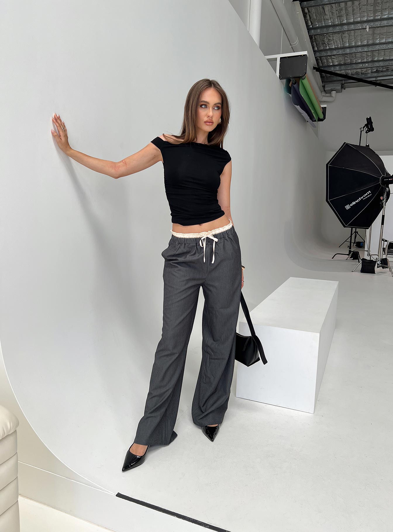 side view of model wearing Princess Polly Seraphic Pants Charcoal Stripe High Waisted Pants 