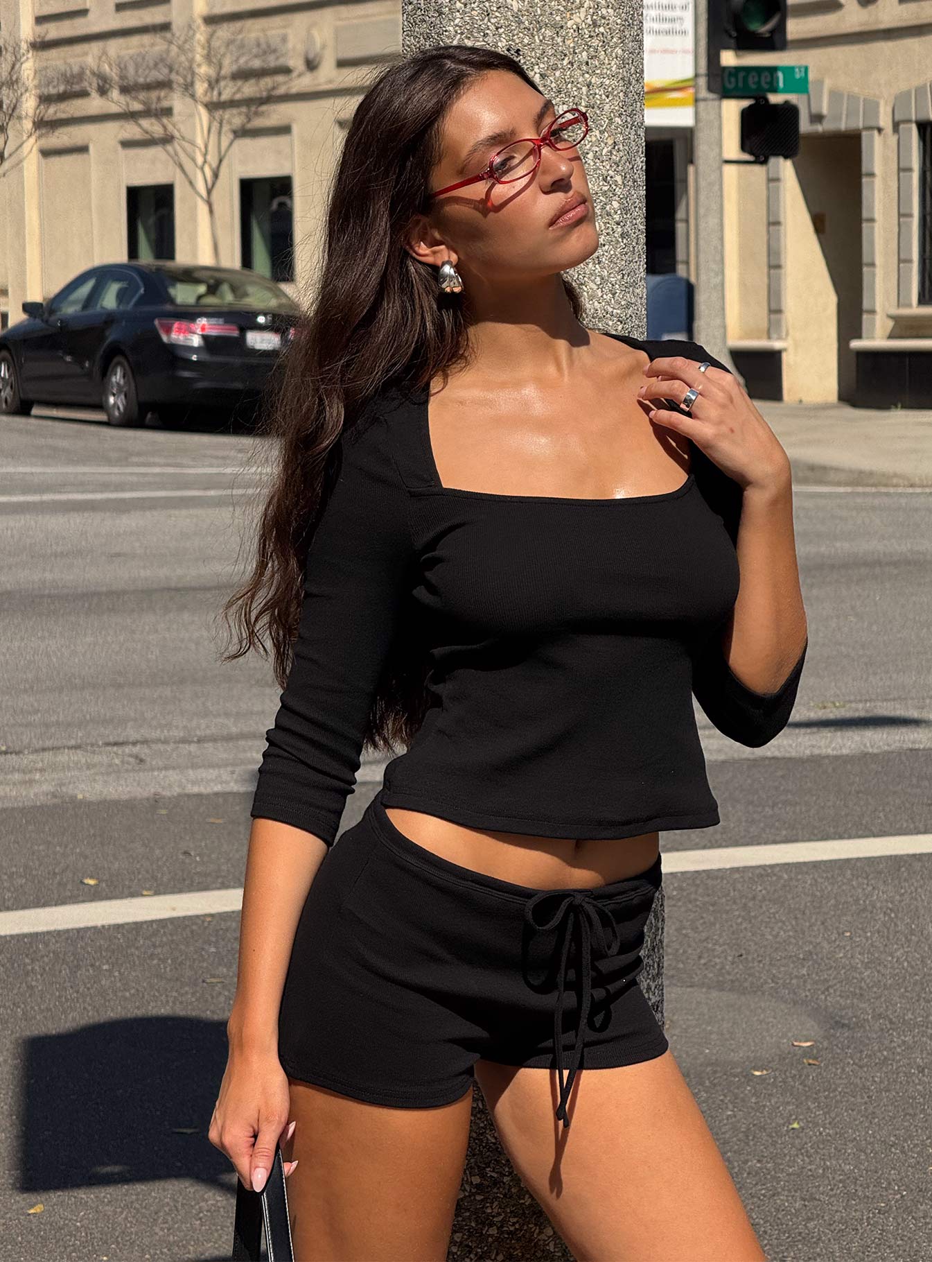 side view of model wearing Princess Polly Gracious Low Rise Mini Short Black Low Rise Shorts 