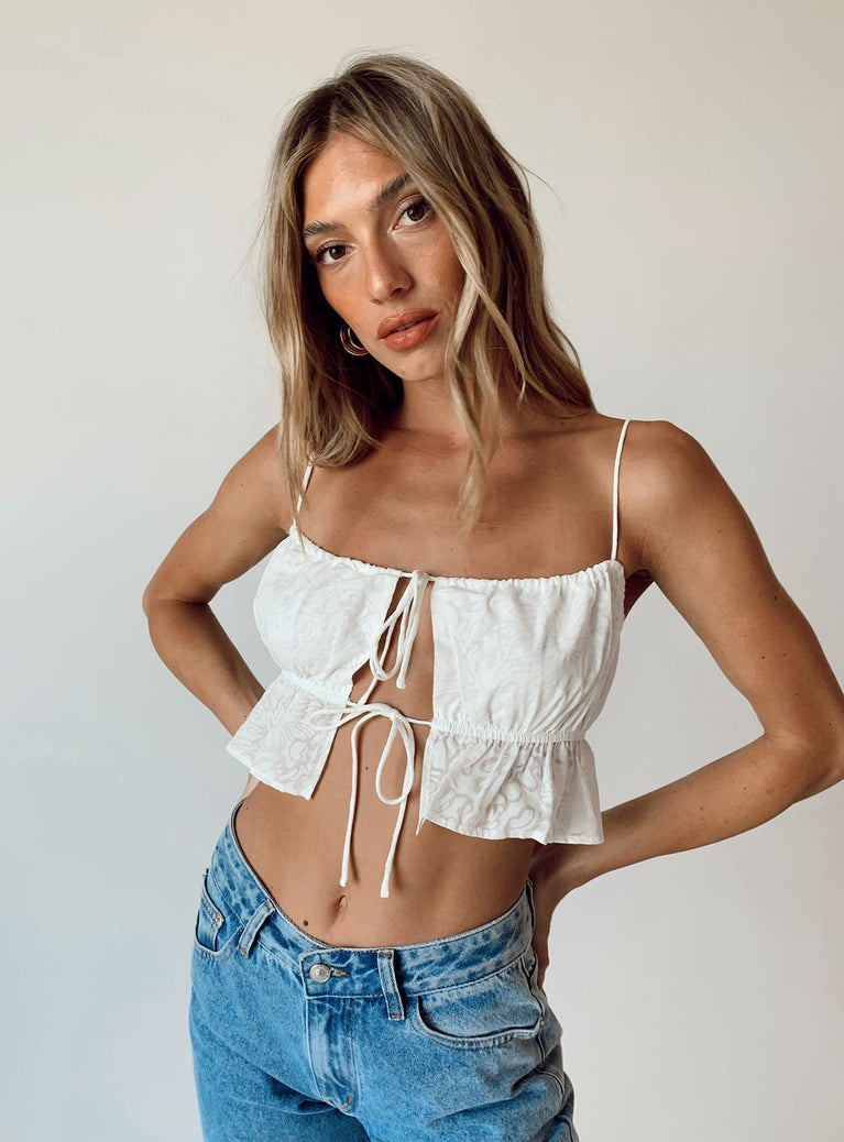 White crop top Sheer material  Fixed shoulder straps  Adjustable coverage Double tie fastening at front  Elasticated underbust band  Frill hem 