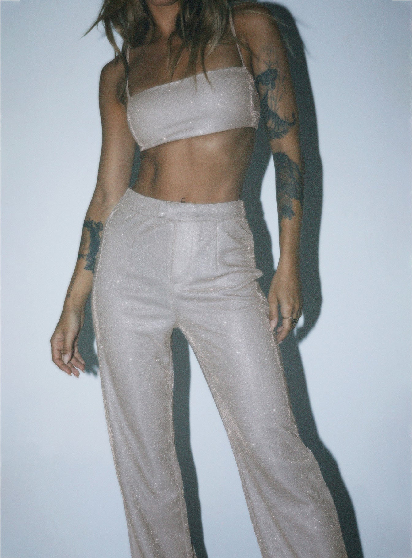 Matching set Sparkly material Crop top Adjustable shoulder straps Zip fastening at back Pants High rise Zip & clasp fastening  Subtle pleats at waist Straight leg