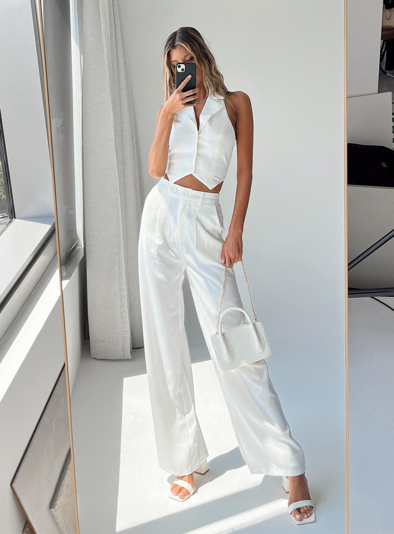 White matching set Vest top Fixed halter neck Button front fastening  High waisted pants  Zip & button fastening  Belt looped waist  Twin hop pockets  Elasticated waistband  Pleated design  Wide leg 