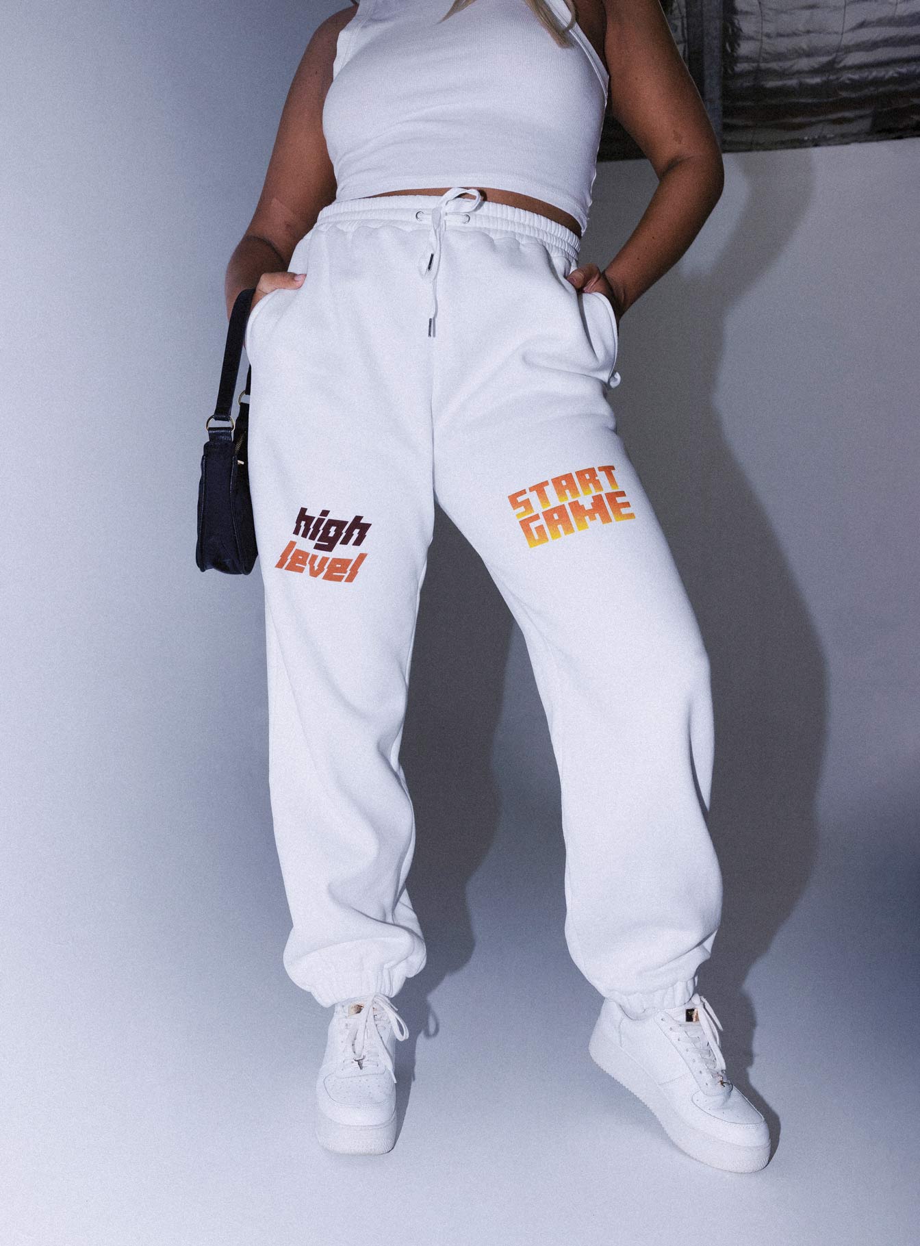 front view of model wearing Princess Polly Jasmine Graphic Track Pants White 