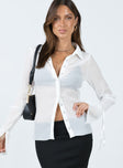 Long sleeve top Pleated sheer material Classic collar Button front fastening Silver press buttons Tie detail at wrists