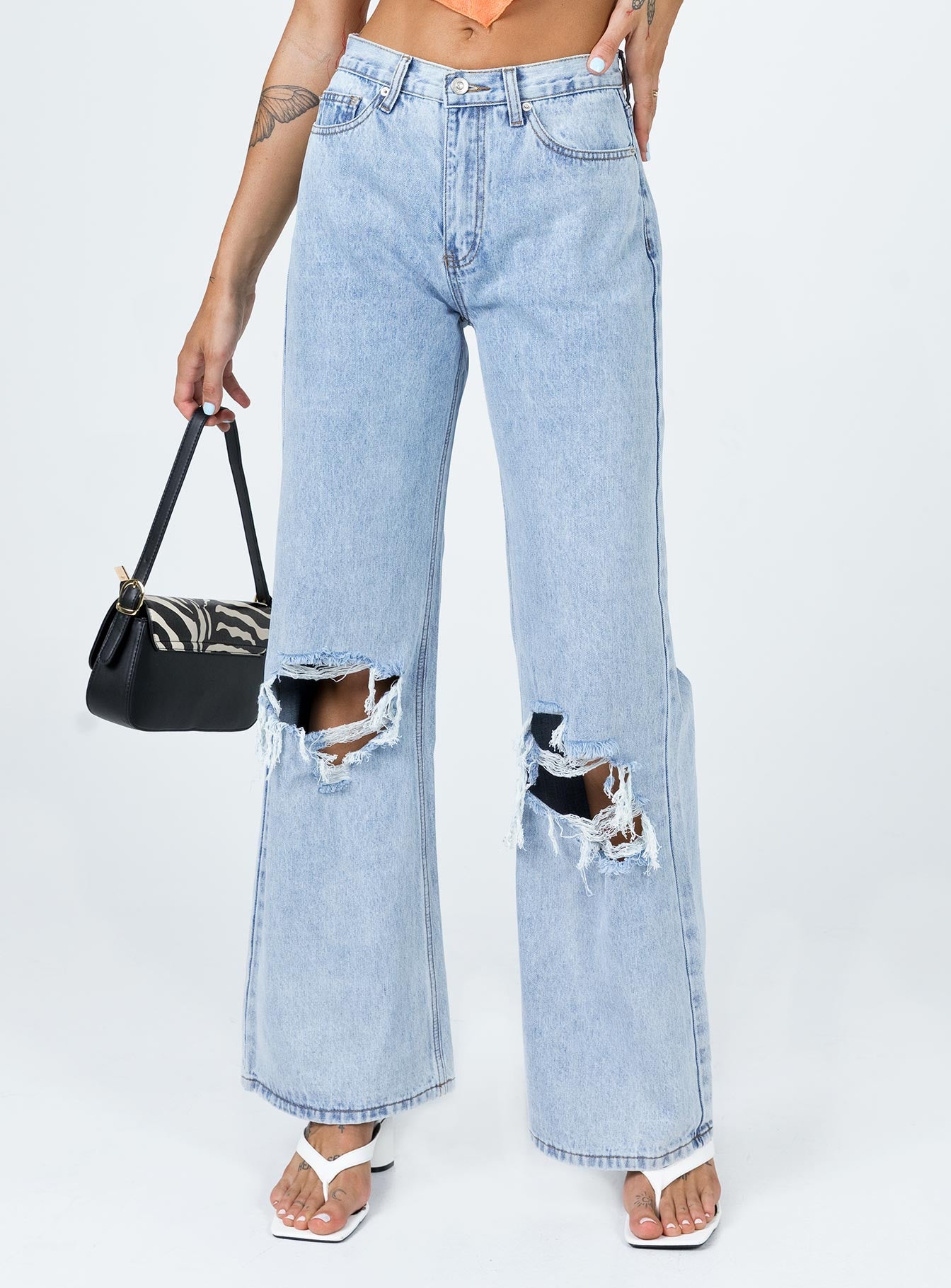 back view of model wearing Princess Polly Maple Flare Jeans Knee Rips Light Wash Denim Mid Rise 