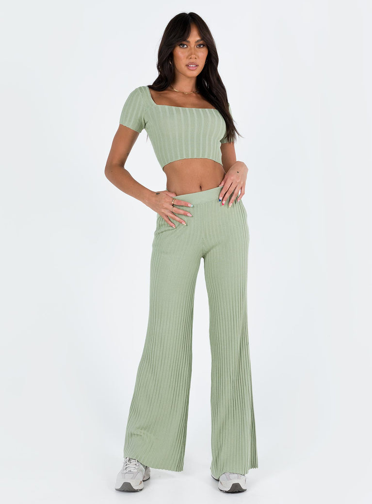 Two piece set Knit ribbed material Crop top Inner silicone strip along shoulders Wide neckline High waisted pants Thick elasticated waistband Twin hip pockets Wide flared leg