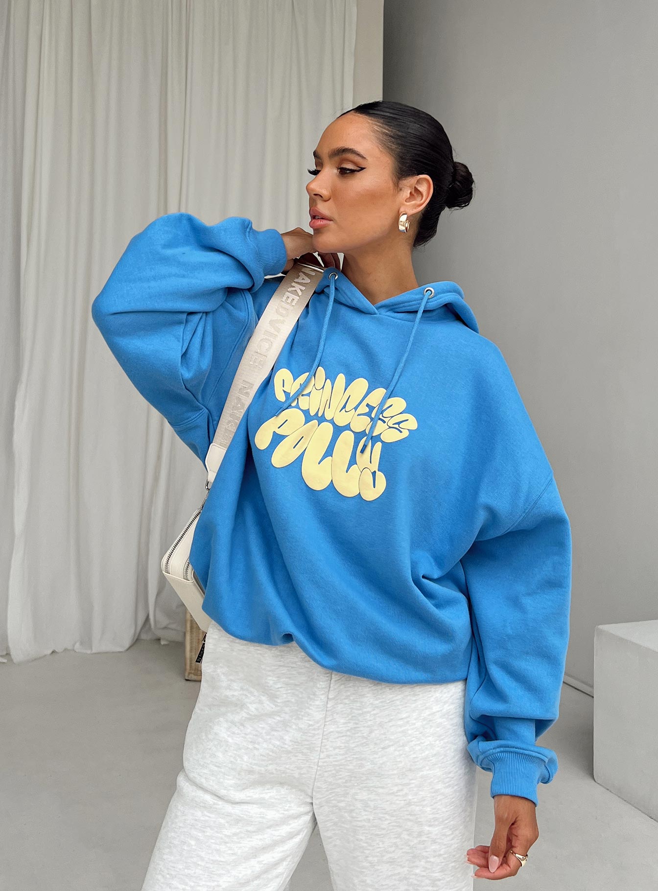 back view of model wearing Princess Polly Princess Polly Hooded Sweatshirt Bubble Text Blue / Yellow Long 