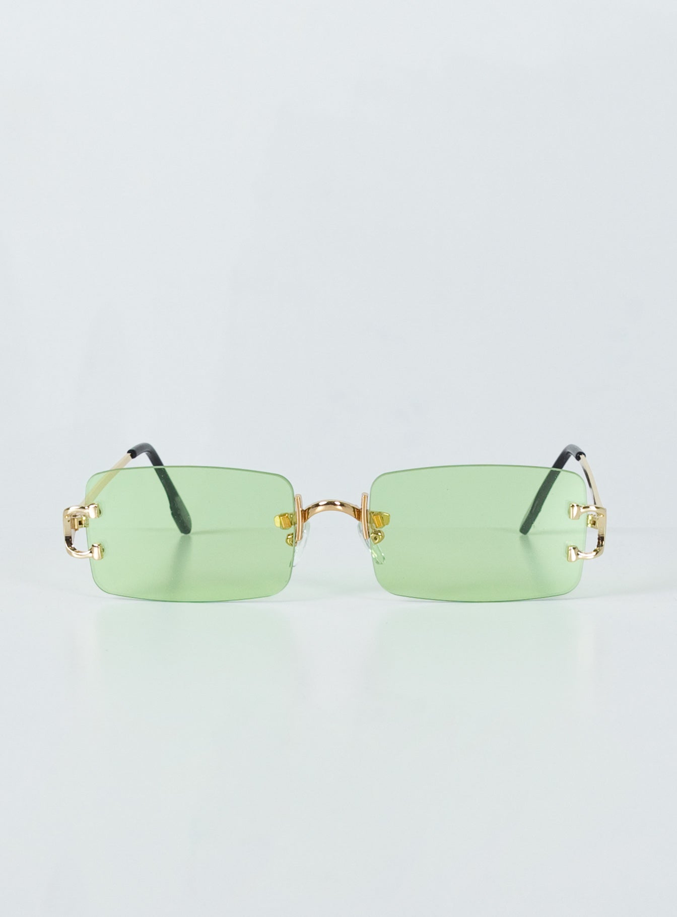 Sunglasses  50% PC 50% Metal UV 400 Frameless design  Gold-toned metal arms  Adjustable silicone nose pads  Green tinted lenses 