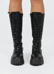 Combat boots Faux leather material  Lace up front  Zip fastening at side  Chunky base  Treaded sole  Mid-calf length 