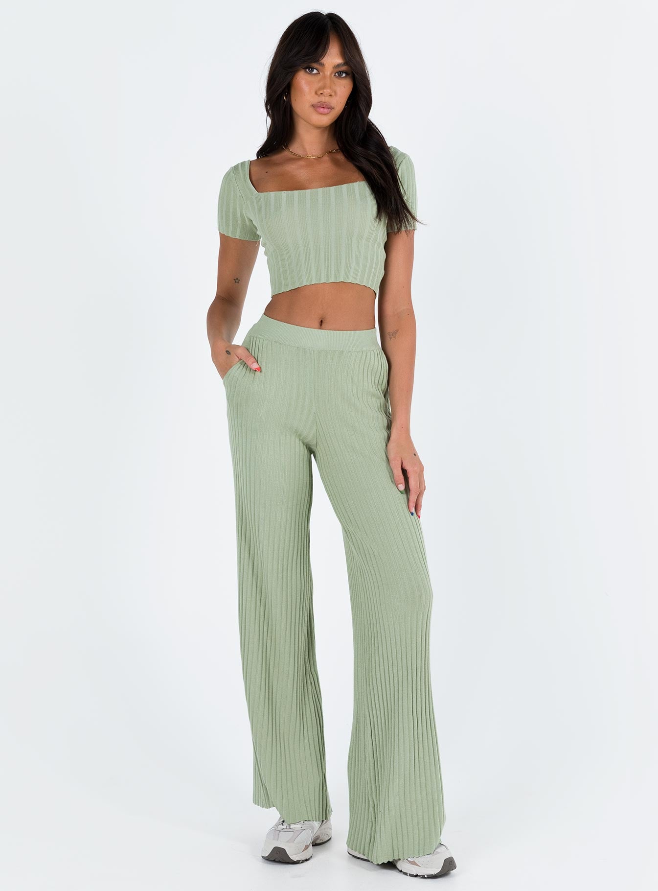 Two piece set Knit ribbed material Crop top Inner silicone strip along shoulders Wide neckline High waisted pants Thick elasticated waistband Twin hip pockets Wide flared leg