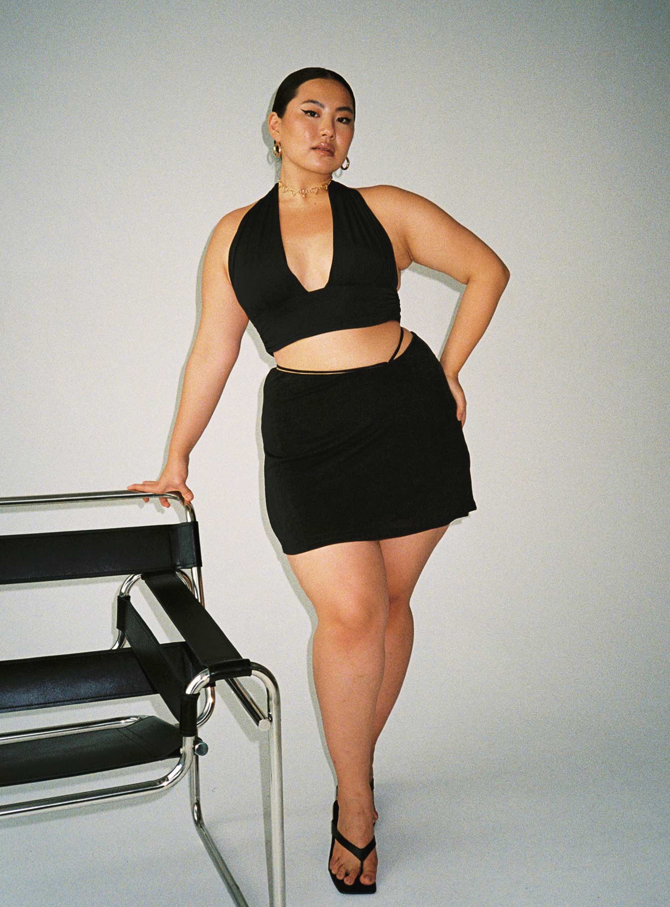 side view of model wearing Princess Polly Jordy Top Black Curve Eco Sleeveless Plunger 