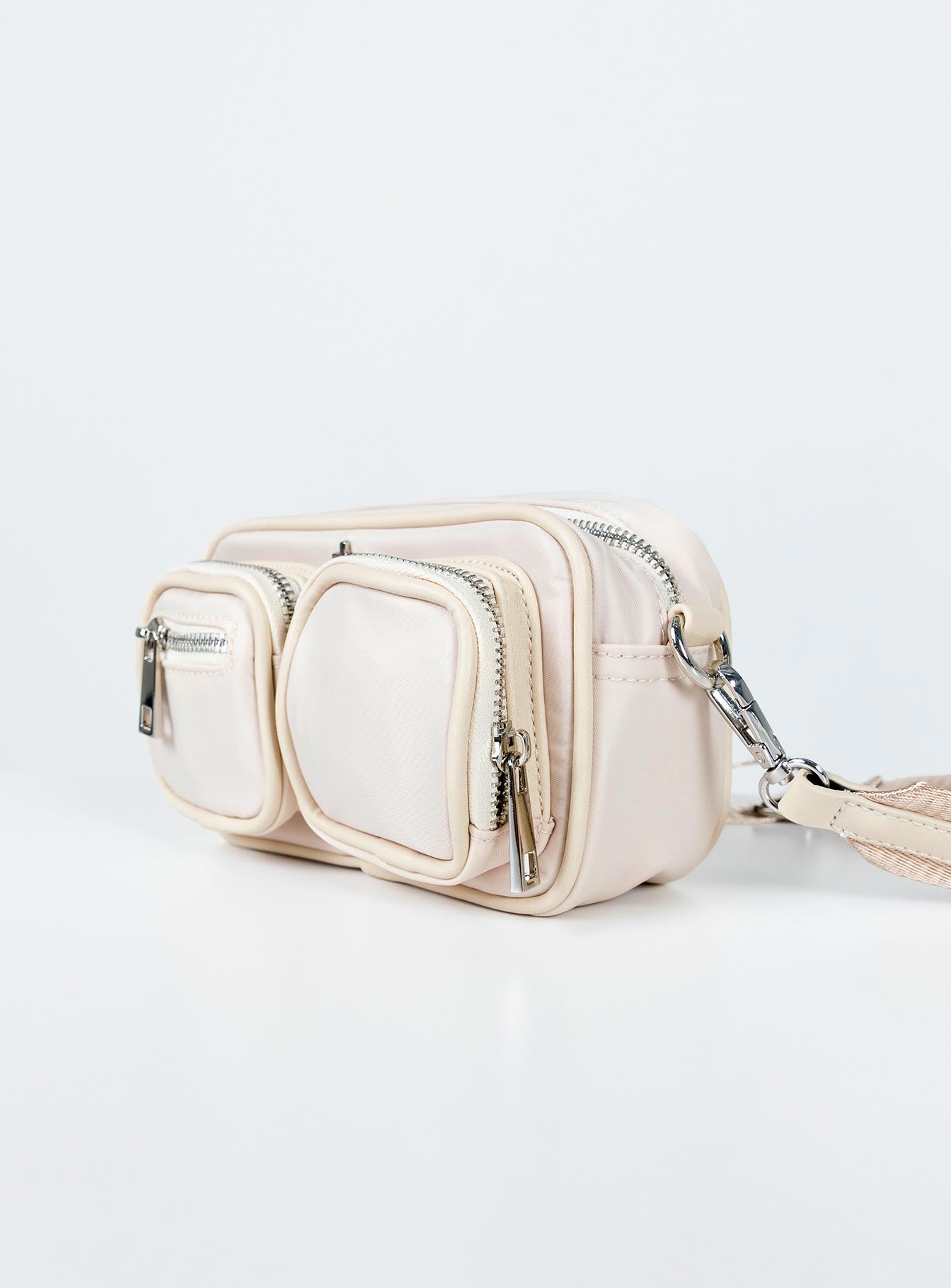 Crossbody bag Nylon material  Silver-toned hardware  Three external pockets  Zip fastenings  Internal pockets  Removable & adjustable strap  Flat base