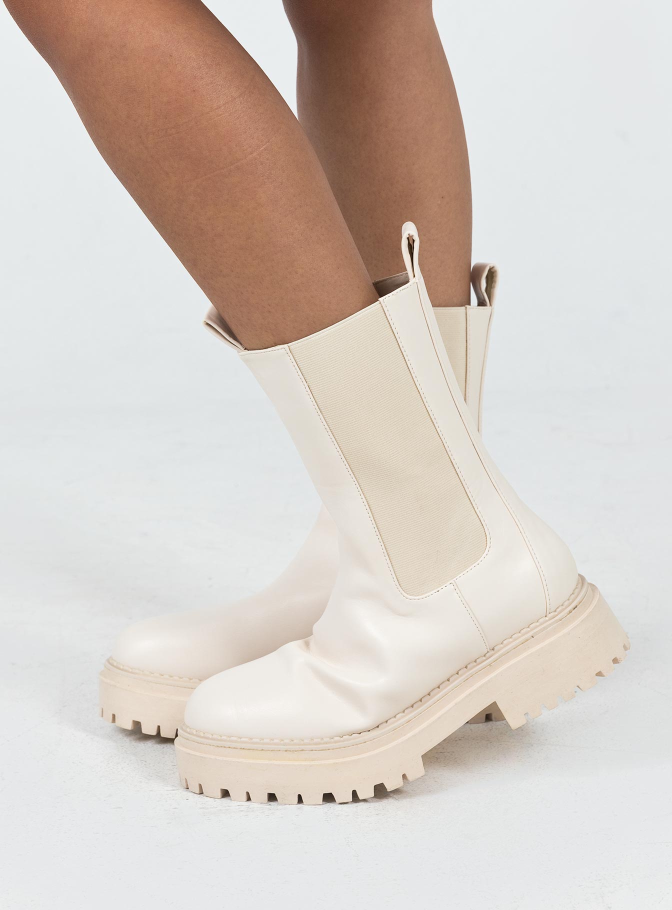 Boots Faux leather material Rounded toe Platform base Ankle pull tab Slip on style