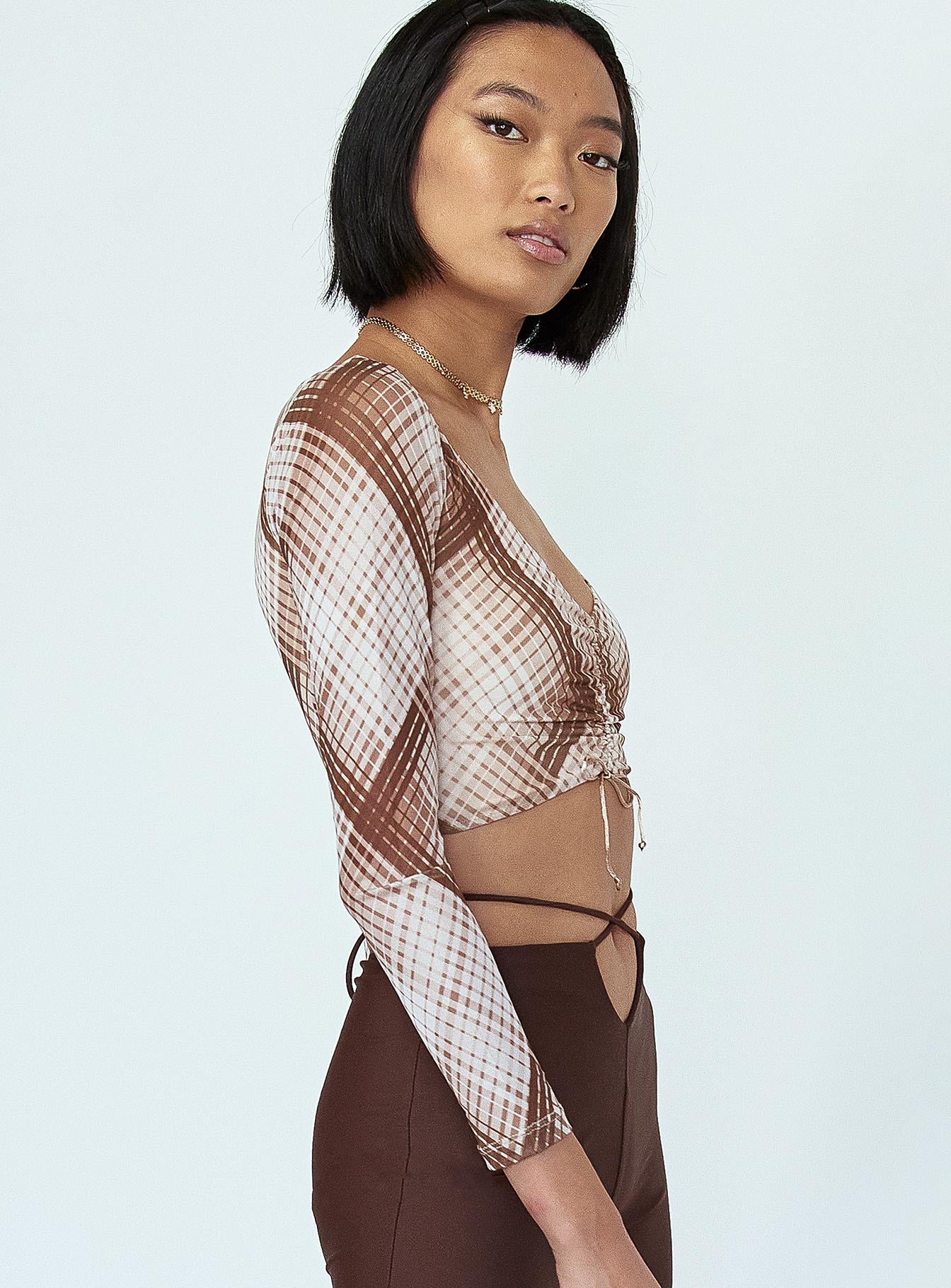 side view of model wearing Princess Polly Lucille Long Sleeve Top Brown Check 
