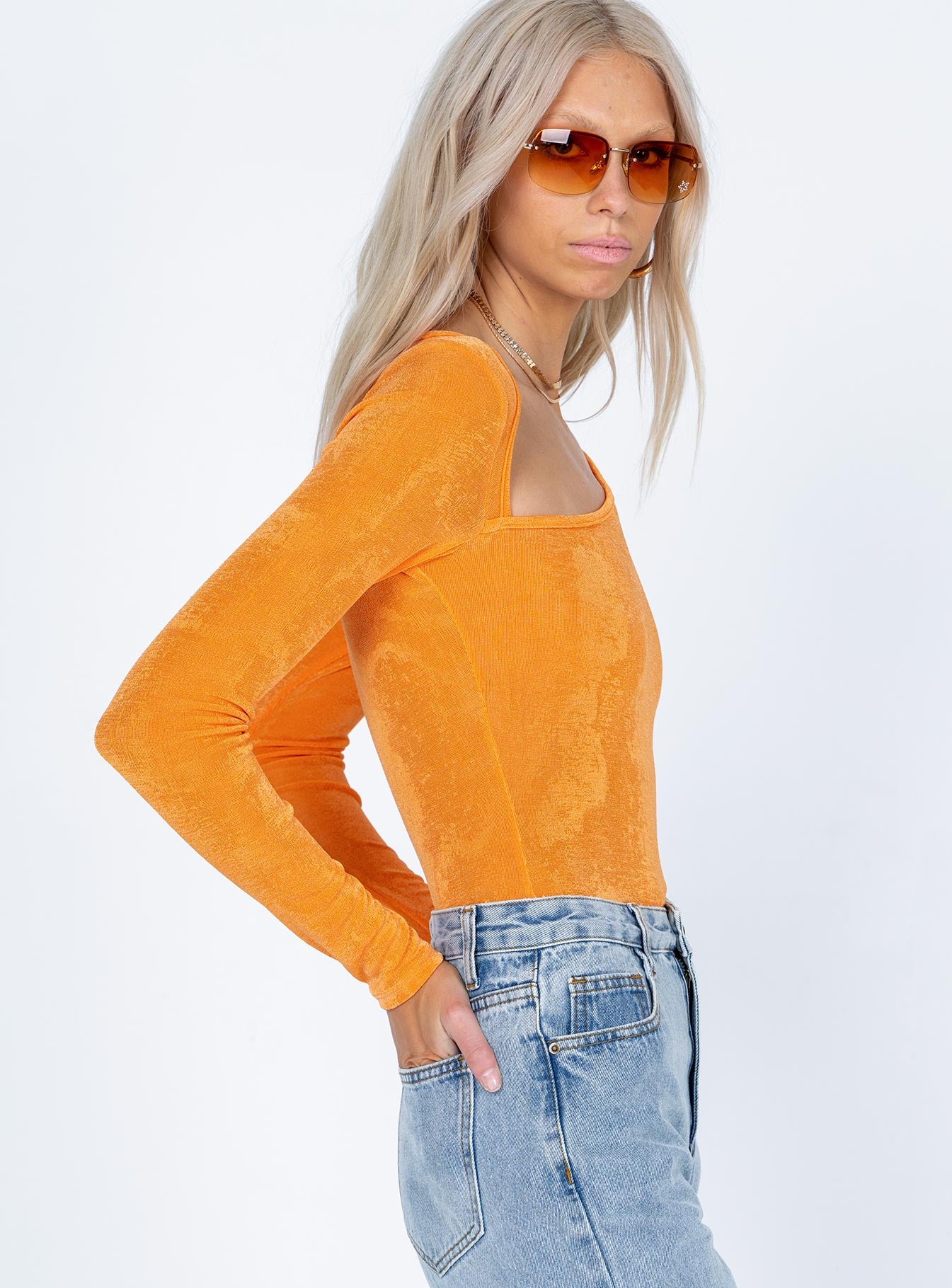 side view of model wearing Princess Polly Maira Long Sleeve Bodysuit Orange Full Sleeves Asymmetric Neckline 