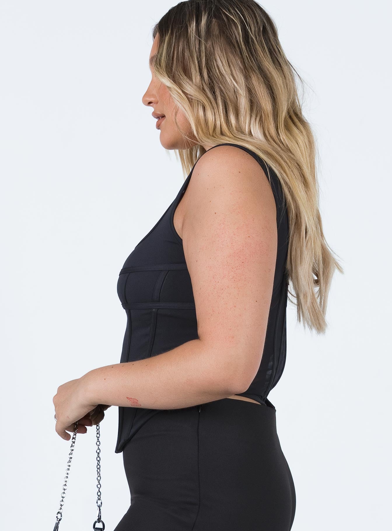 side view of model wearing Princess Polly Normani Top Black Sleeveless Square Neck 