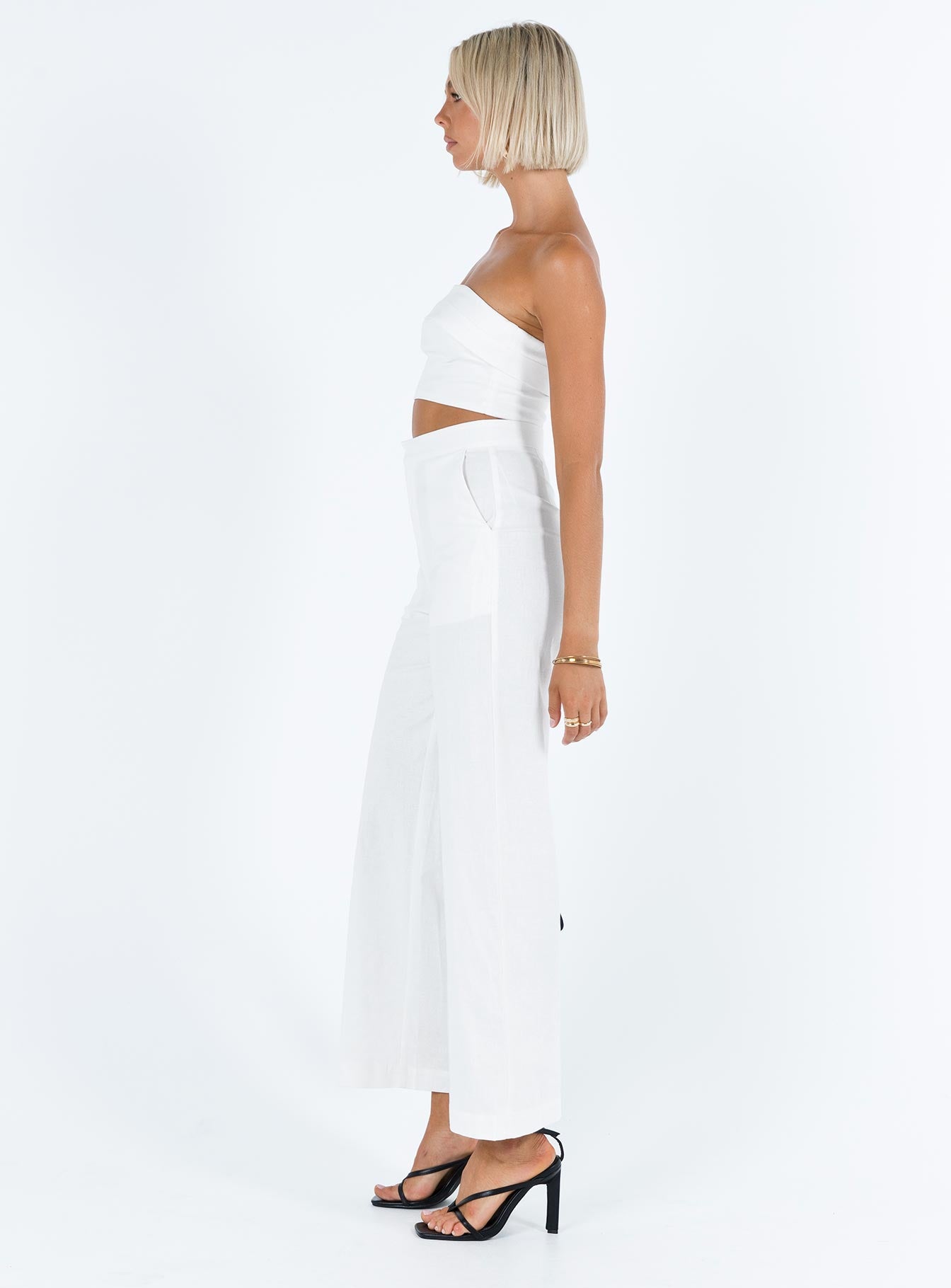 White matching set Linen look material Strapless crop top Folded neckline Inner silicone strip at bust Zip fastening at back High waisted pants Front button and zip fastening  Twin hip pockets