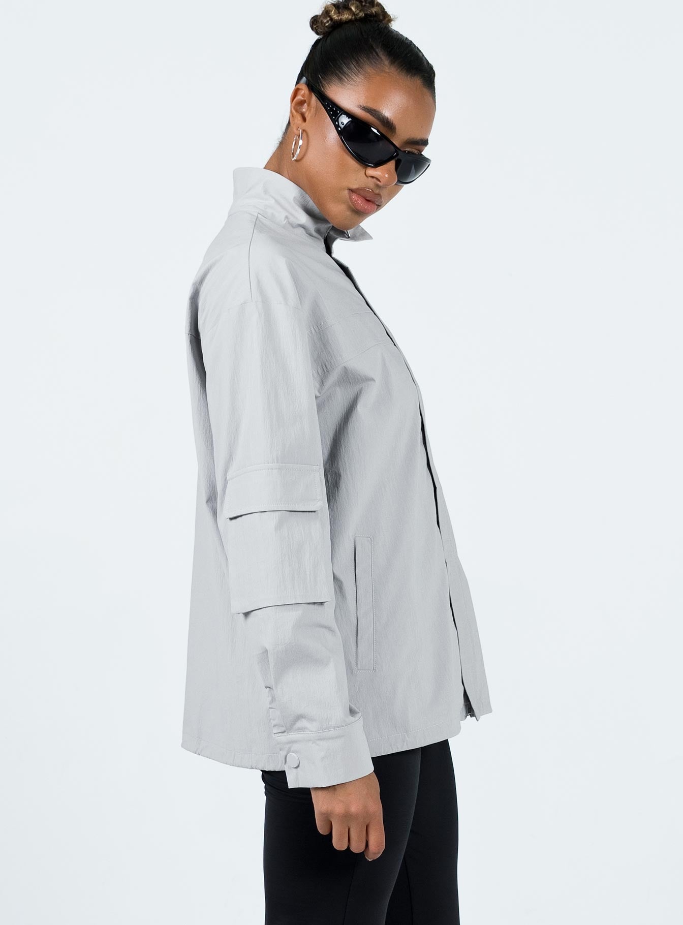 Jacket Windbreaker material High neck Zip front fastening Cargo style pocket on right sleeve Twin front pockets Press studs at cuff Drawstring hem