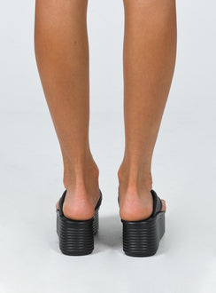 Sandals 100% polyurethane Faux leather material Flip-flop style upper  Exaggerated platform base  Rounded toe  Padded footbed 