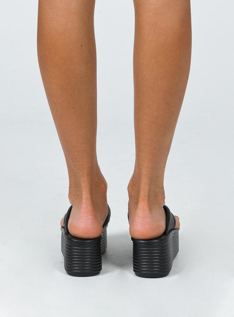 Sandals 100% polyurethane Faux leather material Flip-flop style upper  Exaggerated platform base  Rounded toe  Padded footbed 