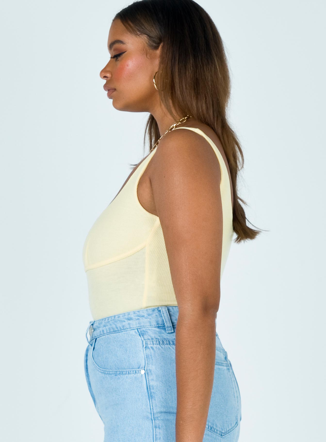 side view of model wearing Princess Polly Crosby Bodysuit Yellow Sleeveless Scoop Neck 