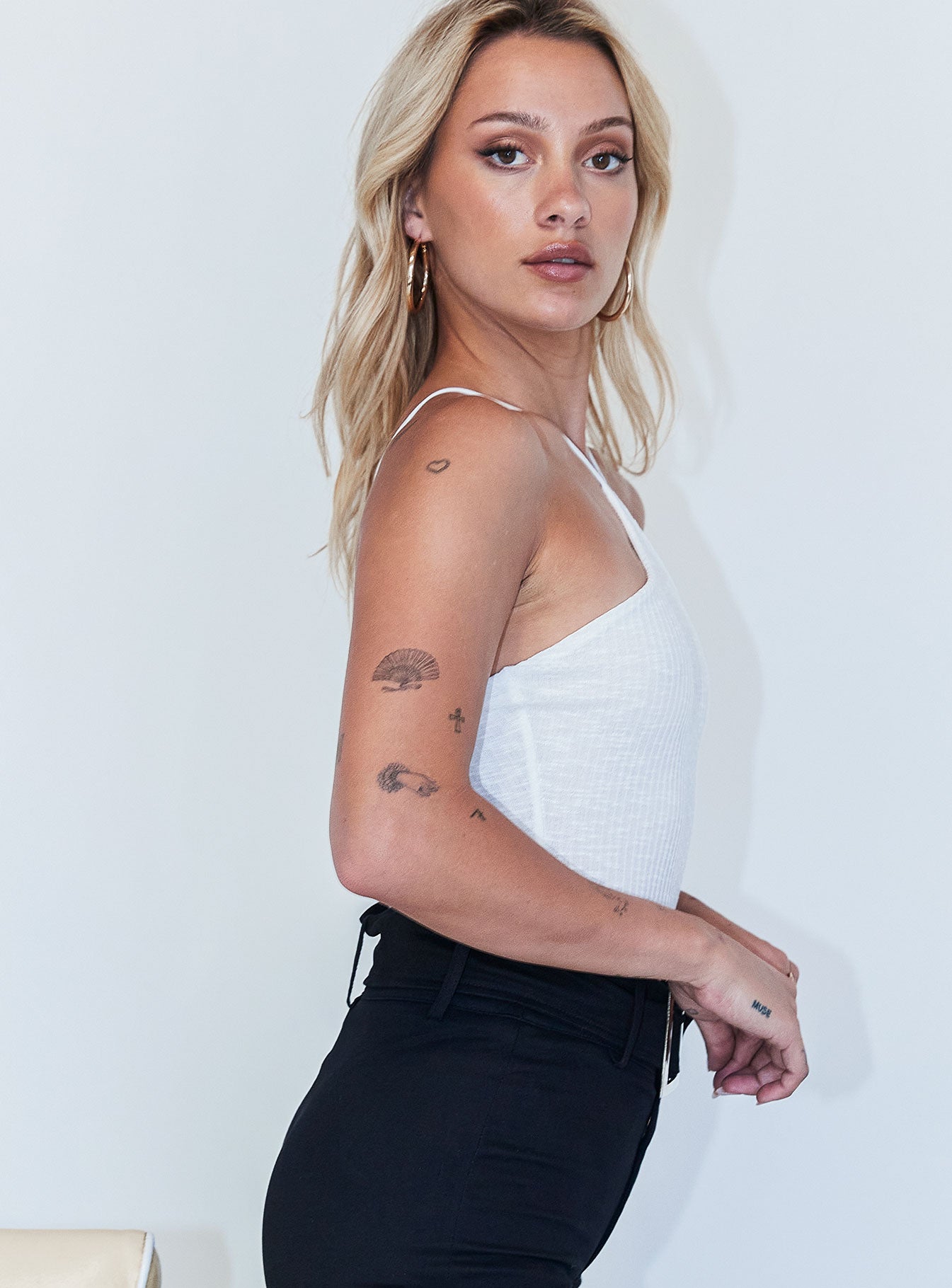 side view of model wearing Princess Polly Morgan Bodysuit White Sleeveless Asymmetric Neckline 