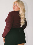 Maroon long sleeve top Ribbed knit material Low cut neckline Split front hem Good stretch Unlined