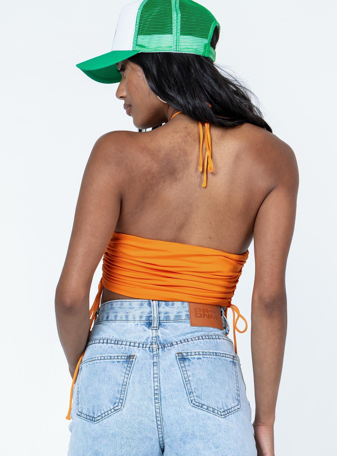 back view of model wearing Princess Polly Jenson Top Orange Sleeveless Asymmetric Neckline 